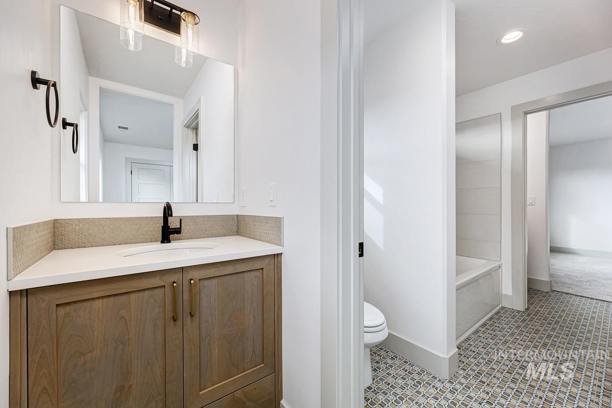 Full bathroom featuring vanity, a bath, and tile patterned floors