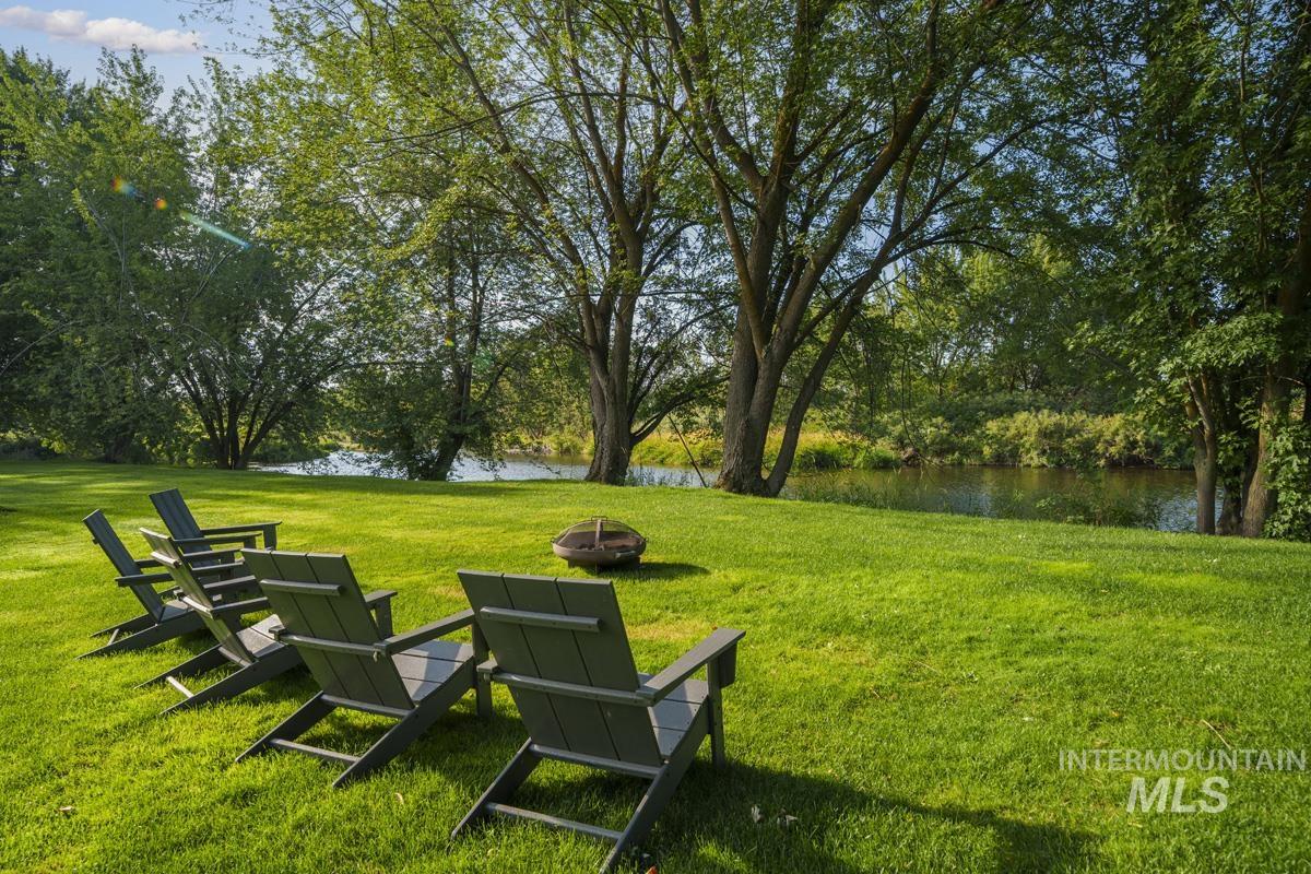 View of home's community featuring a water view, a lawn, and a fire pit