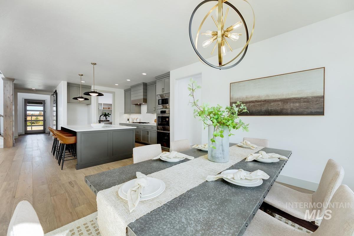 Dining area featuring light wood-type flooring, a chandelier, and recessed lighting