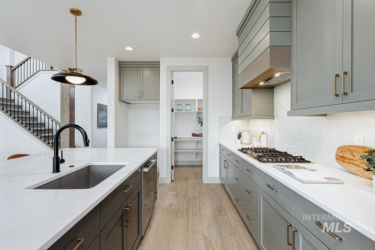 Kitchen with gray cabinetry, pendant lighting, light wood-style flooring, recessed lighting, and backsplash