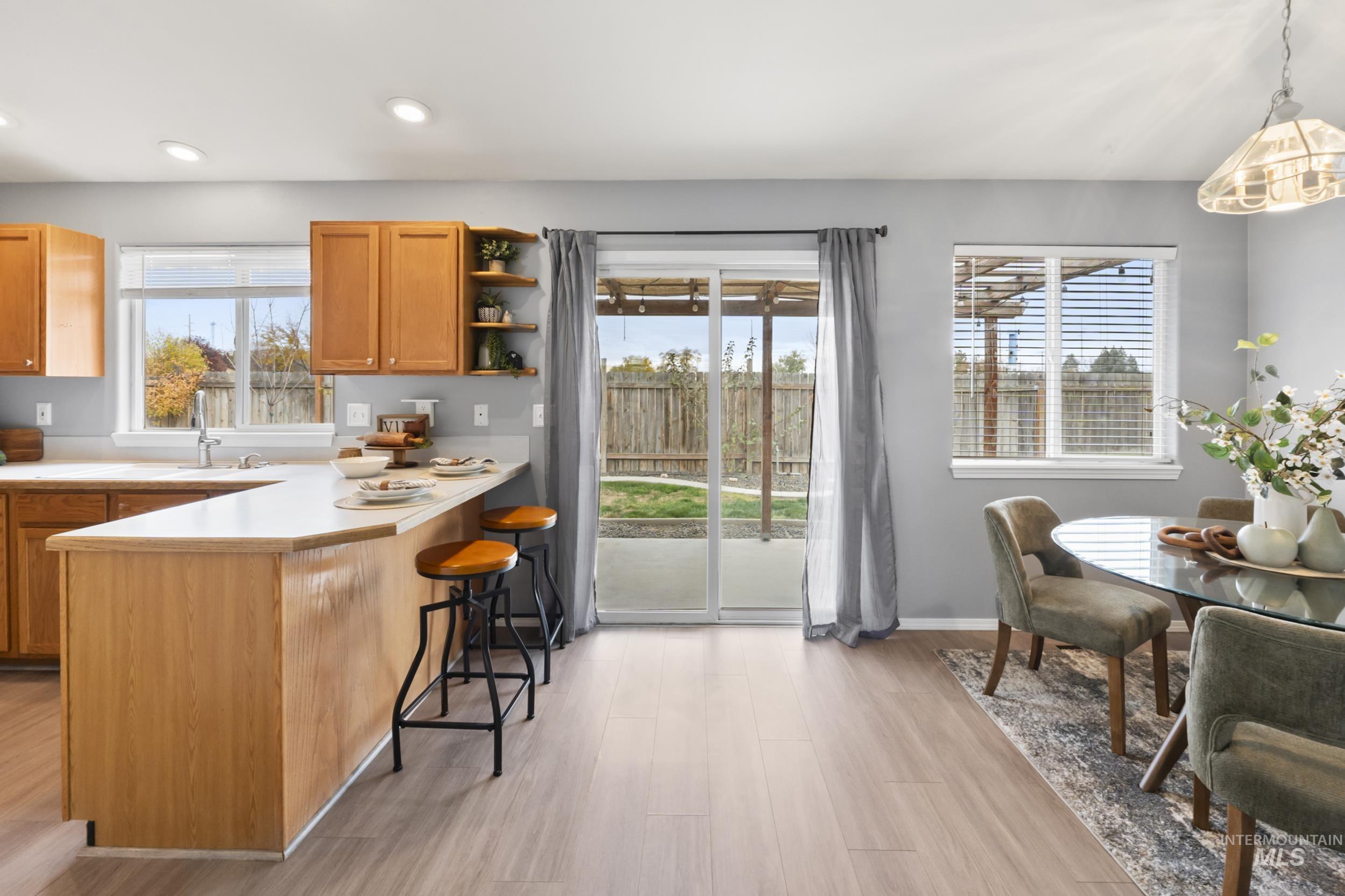 Kitchen featuring light countertops, a kitchen bar, plenty of natural light, a peninsula, and recessed lighting