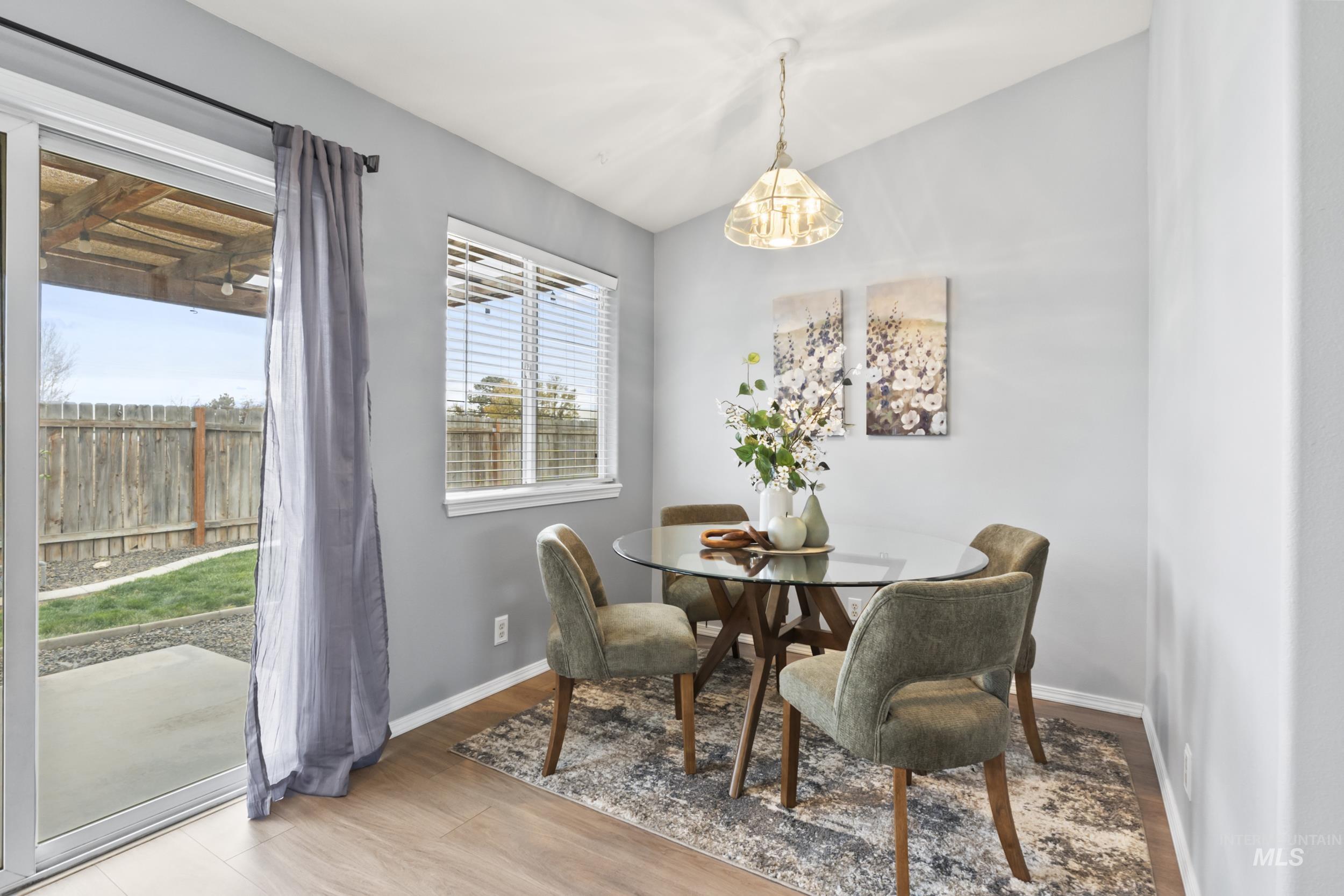 Dining space featuring light wood-style flooring and vaulted ceiling