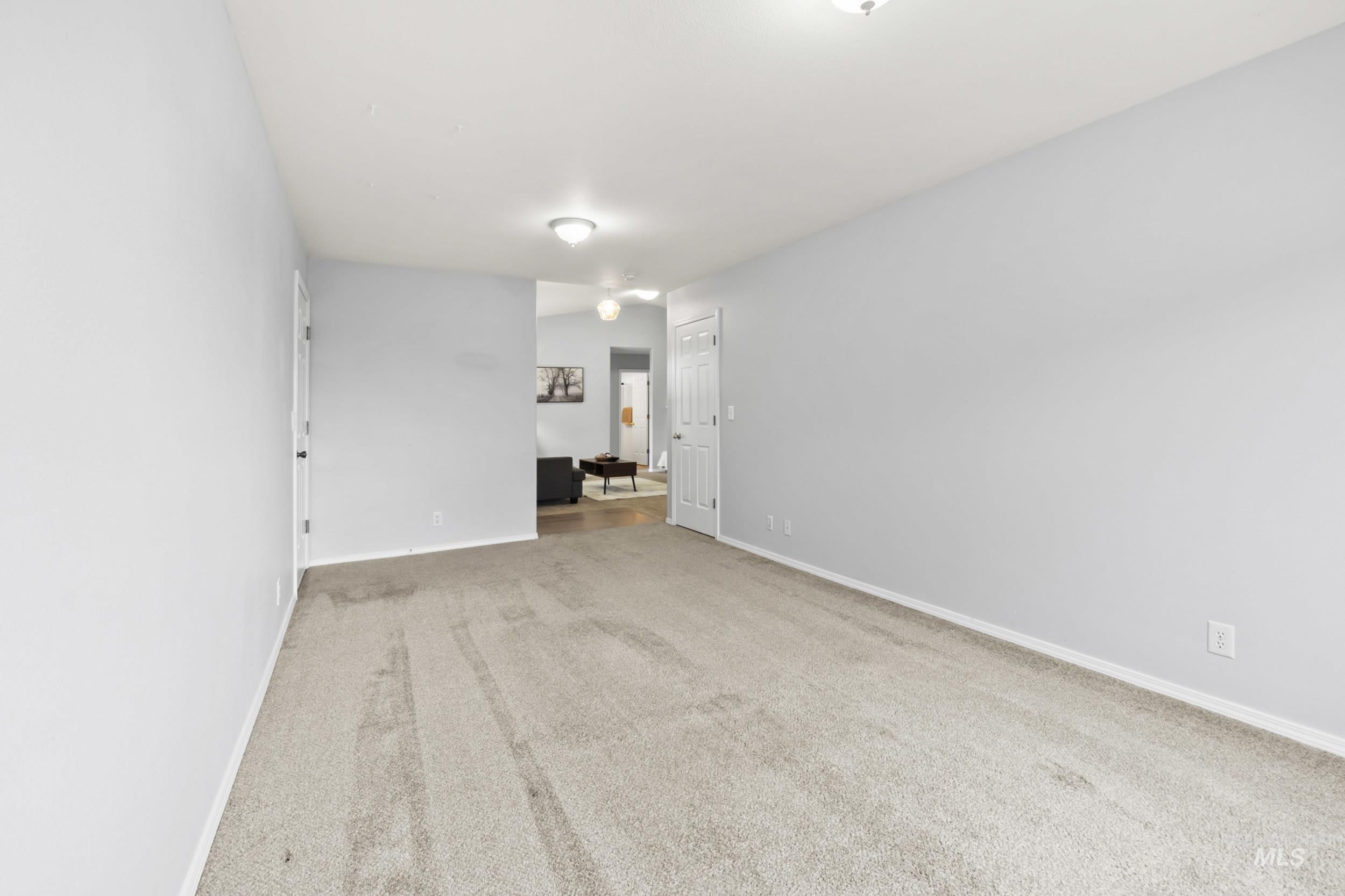 Carpeted spare room with baseboards