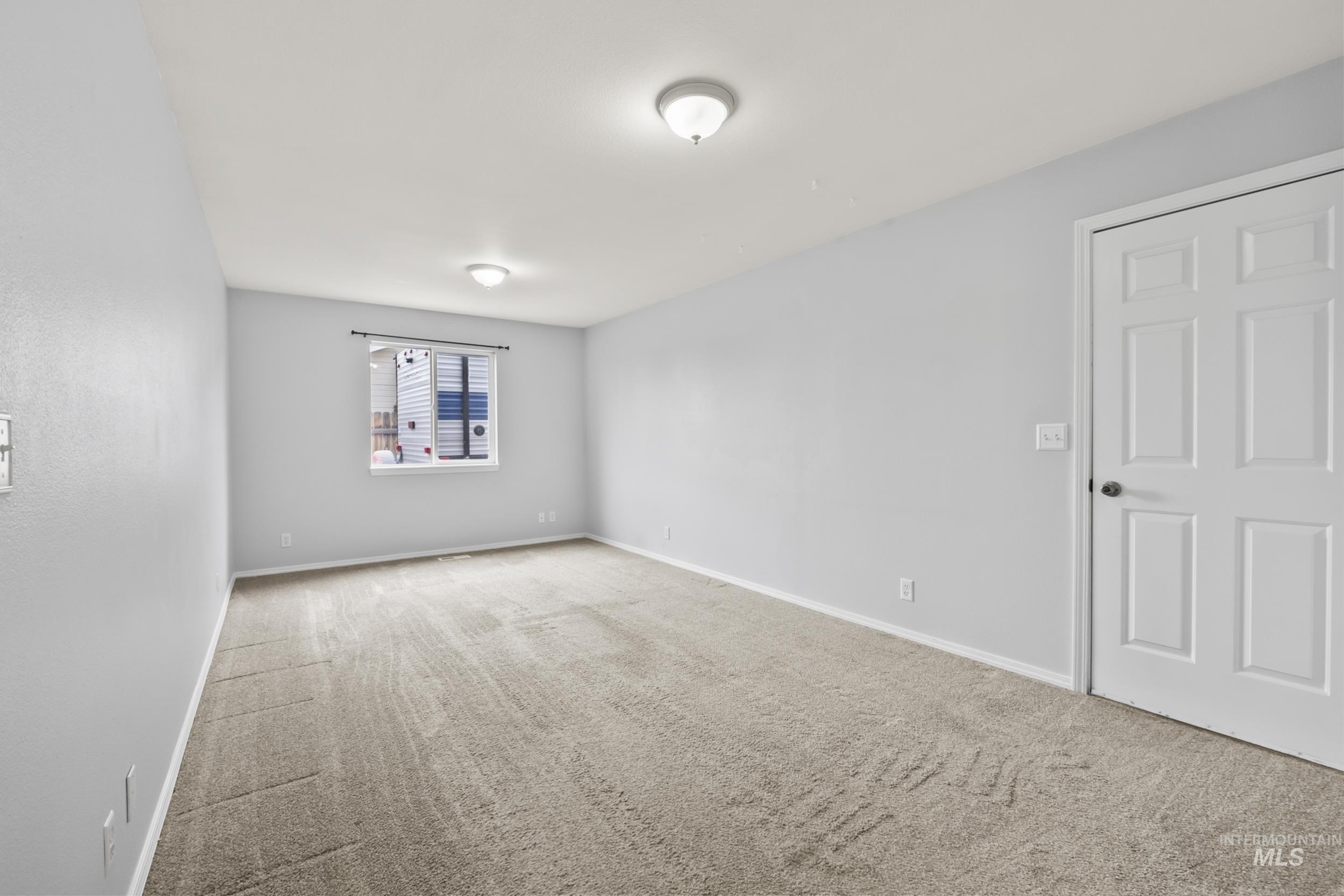 Carpeted spare room with baseboards