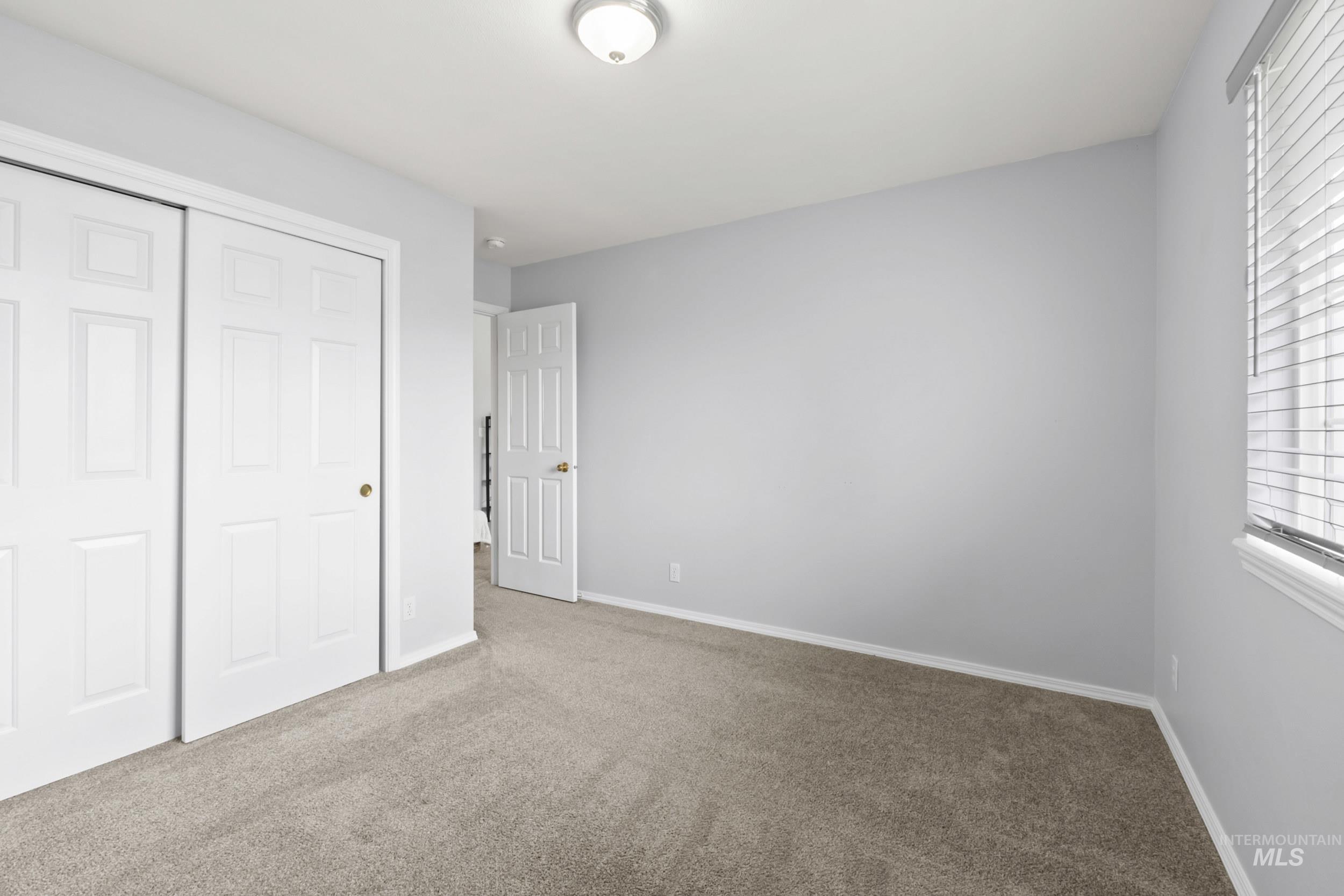 Unfurnished bedroom with carpet and a closet