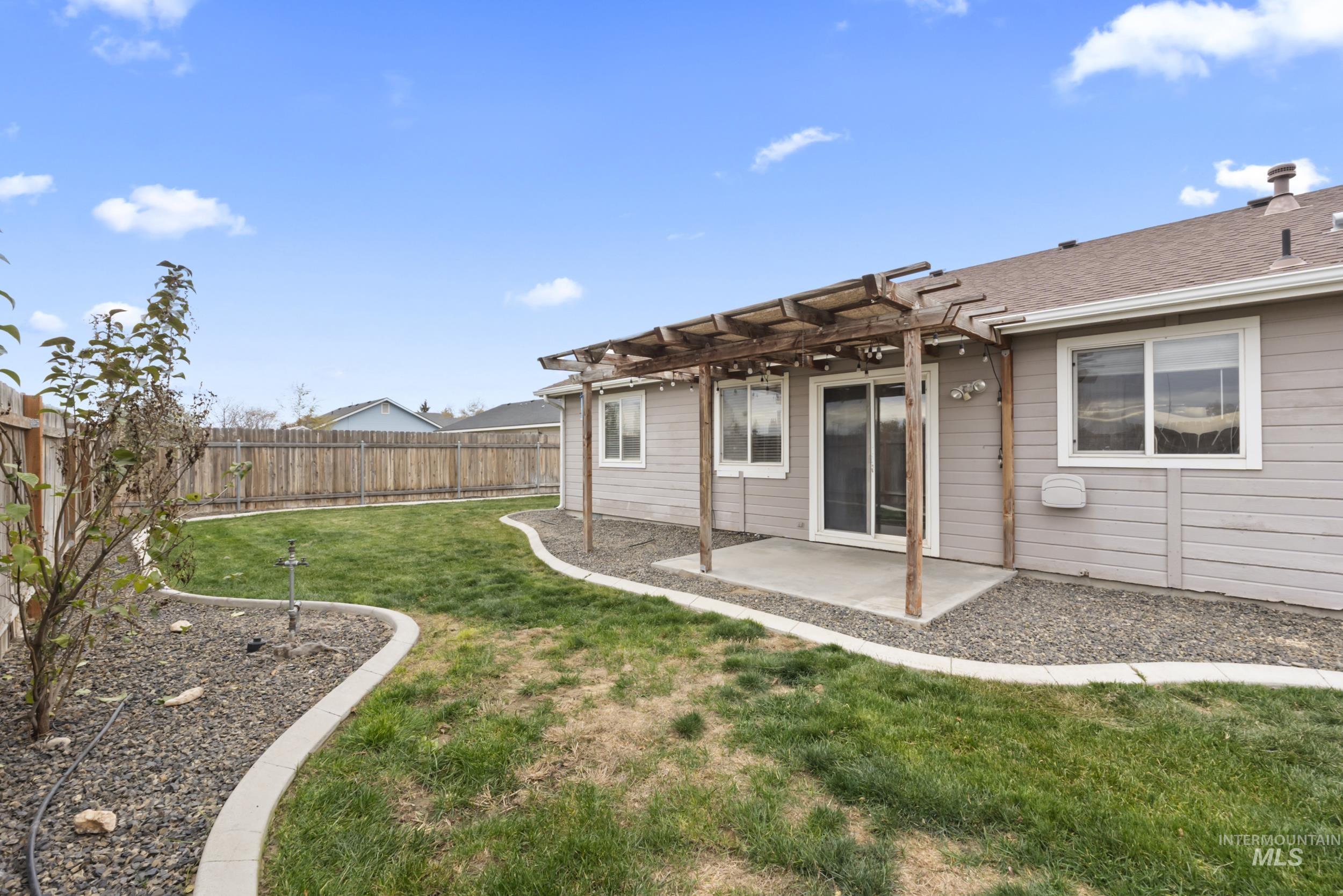 Fenced backyard featuring a pergola and a patio area