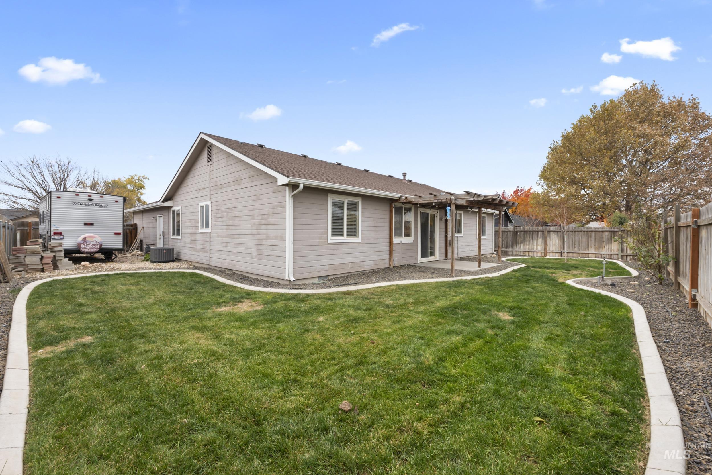 Rear view of property with a fenced backyard, a patio area, and a pergola