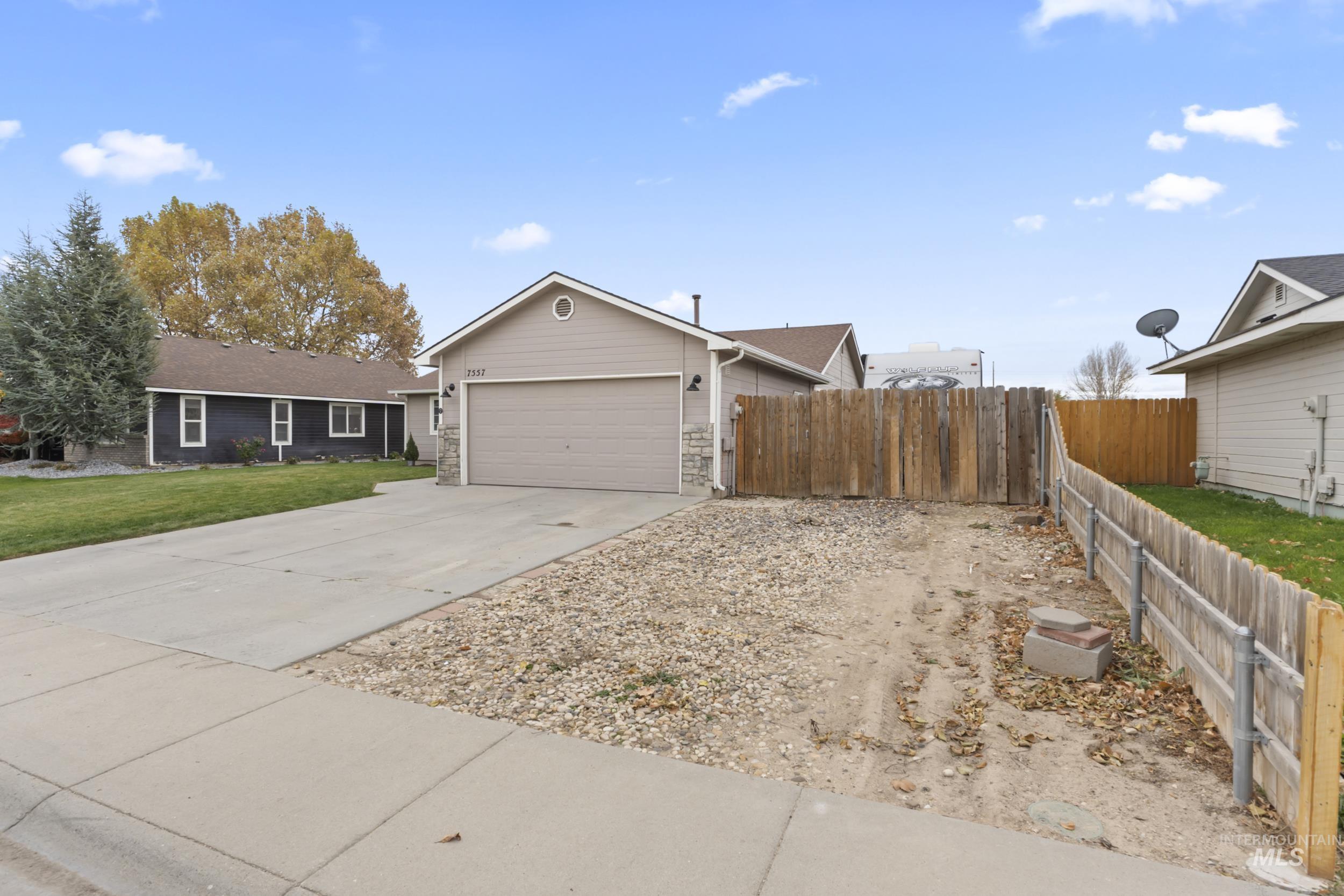 Ranch-style house featuring concrete driveway and an attached garage
