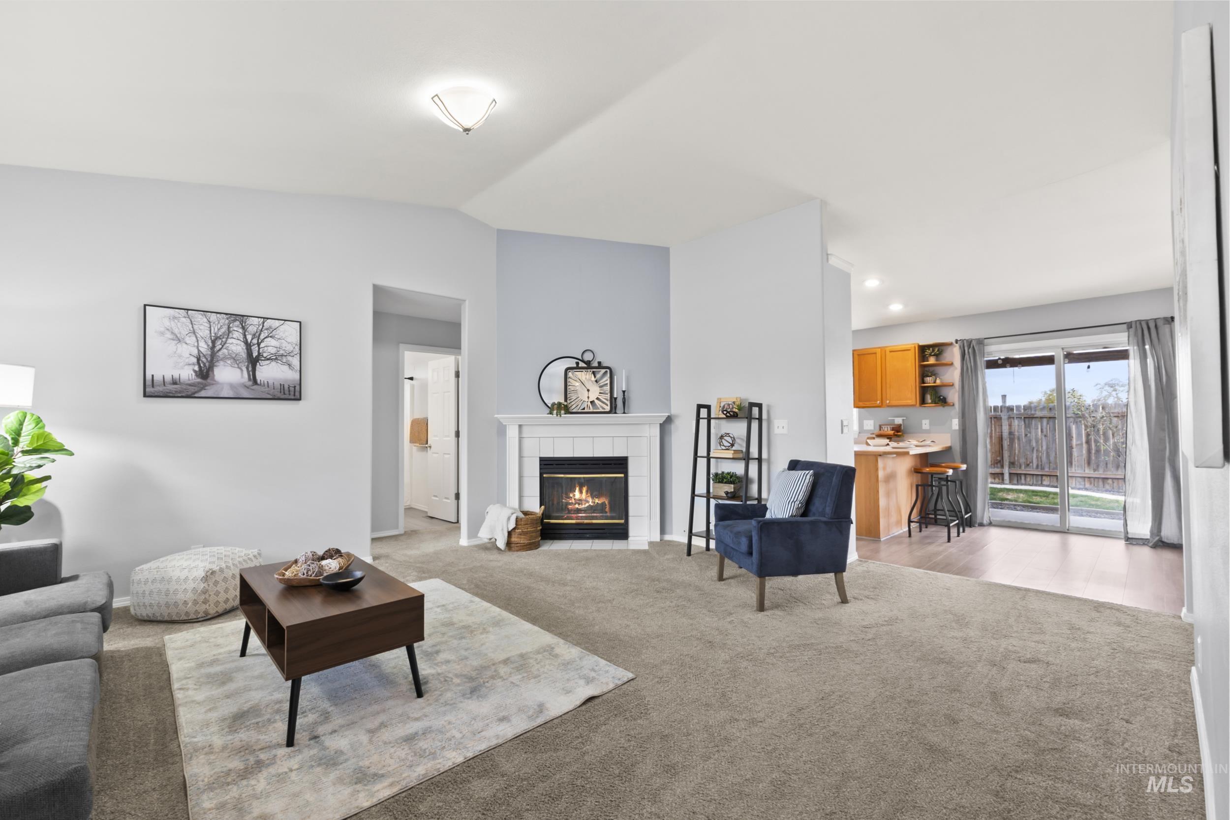 Living area with light carpet, a fireplace, lofted ceiling, and recessed lighting