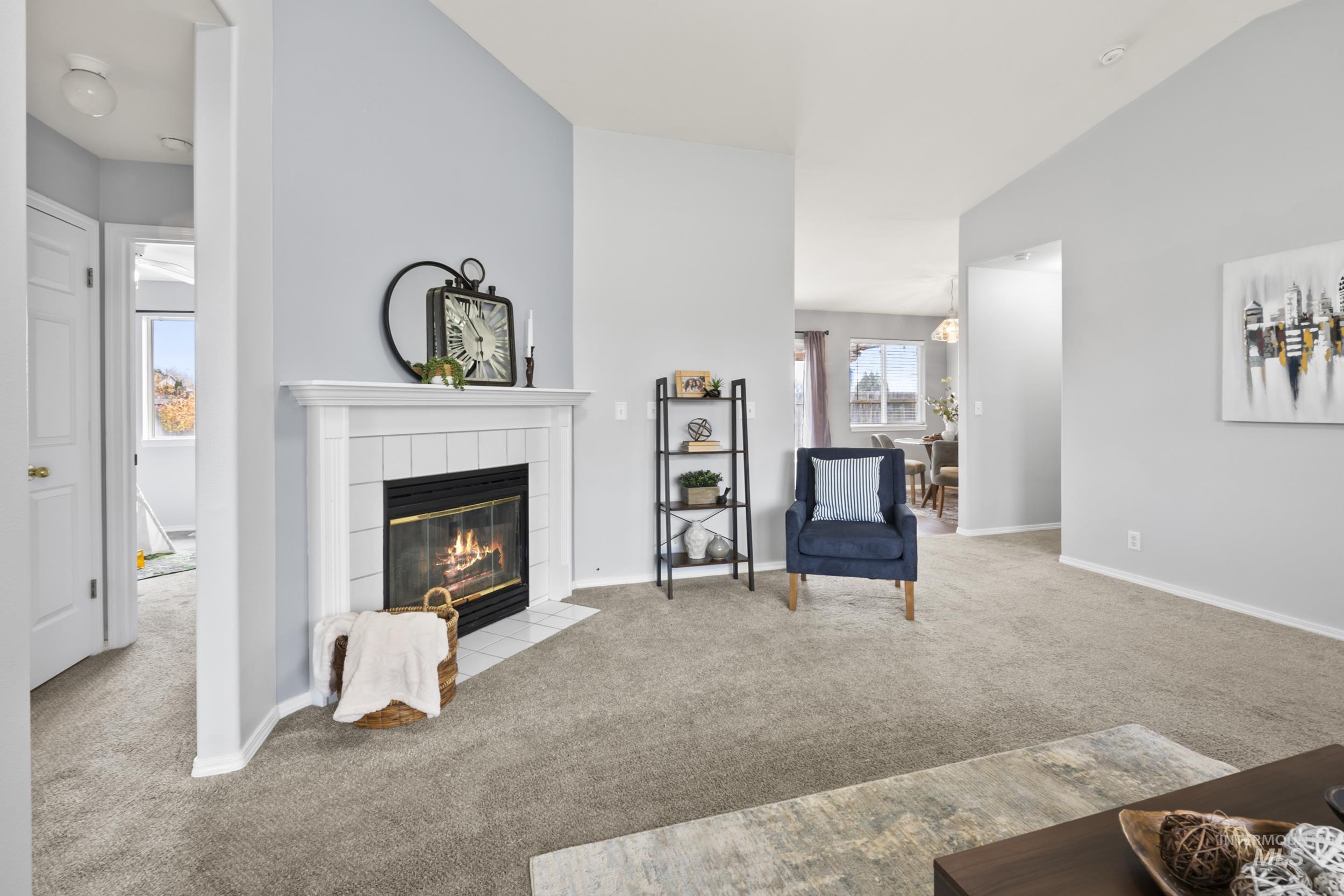 Living room featuring carpet flooring and a tiled fireplace