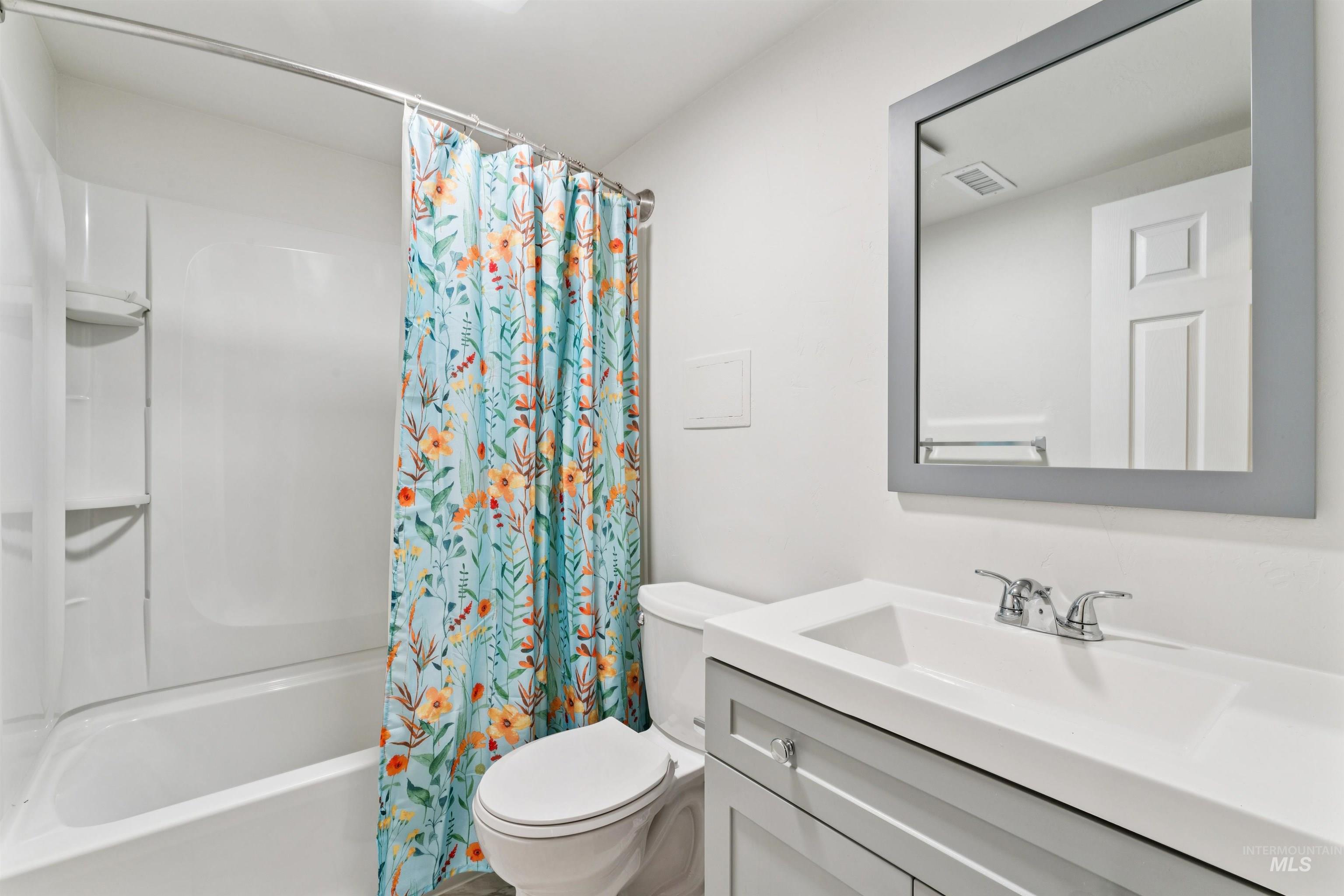 Full bathroom featuring shower / bathtub combination with curtain and vanity