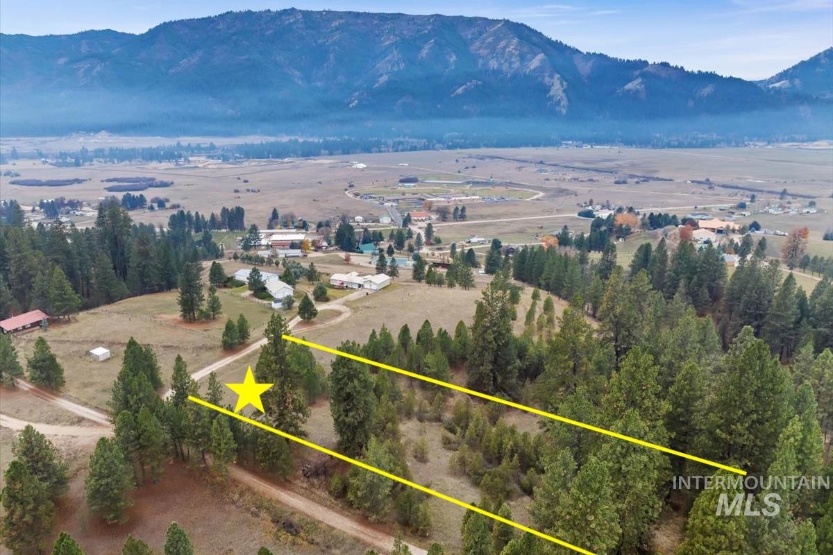 Aerial view of property's location with a mountainous background and property parcel outlined