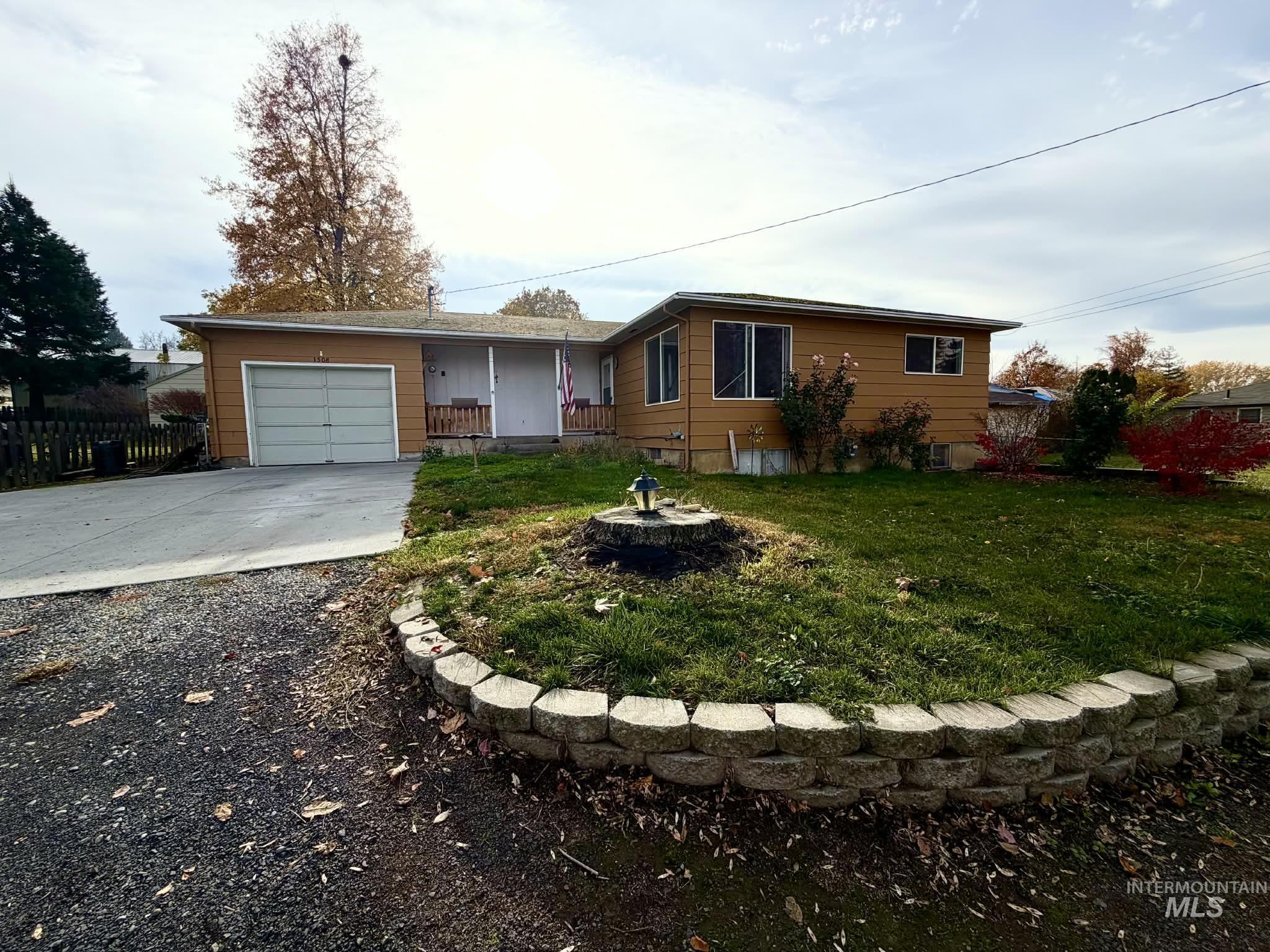 Single story home featuring driveway, a garage, and a porch