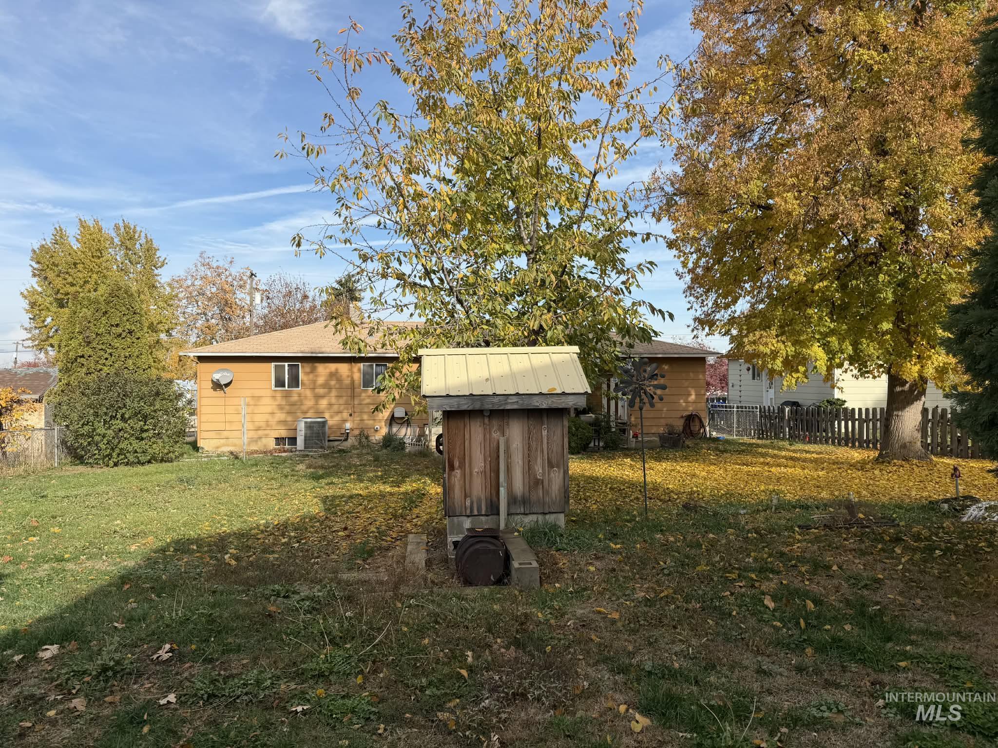 Rear view of property with a storage unit and a chimney