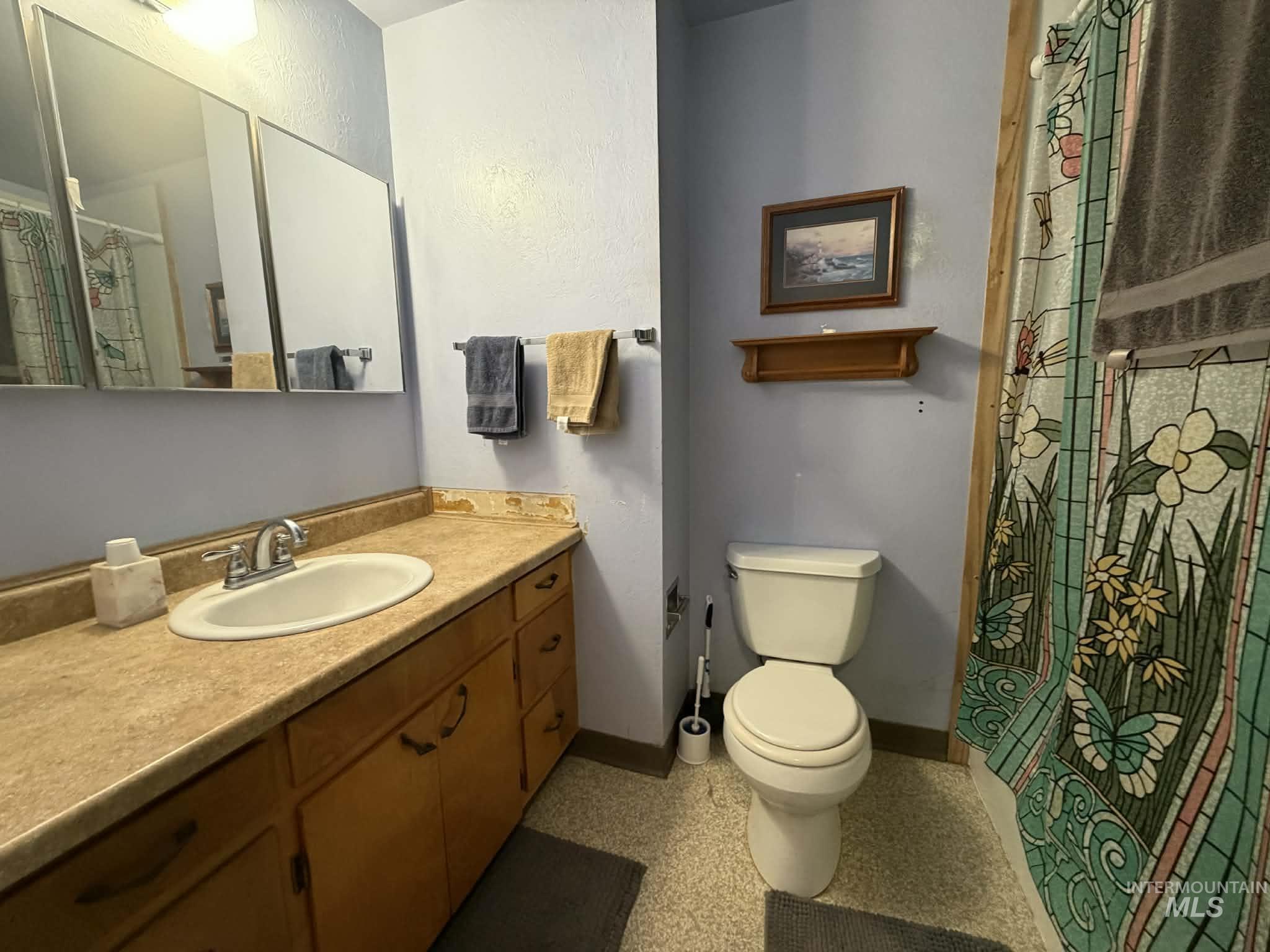 Full bath with a shower with shower curtain and vanity