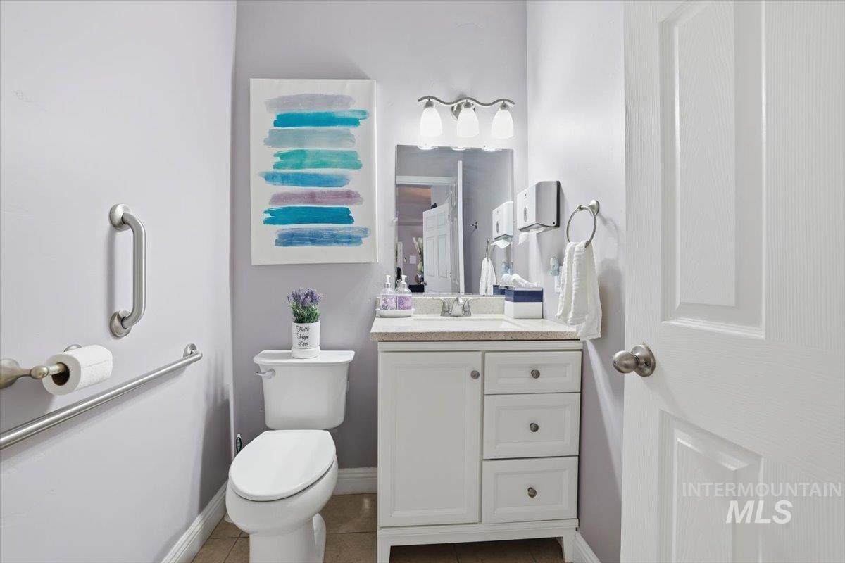 Half bathroom featuring vanity and tile patterned floors