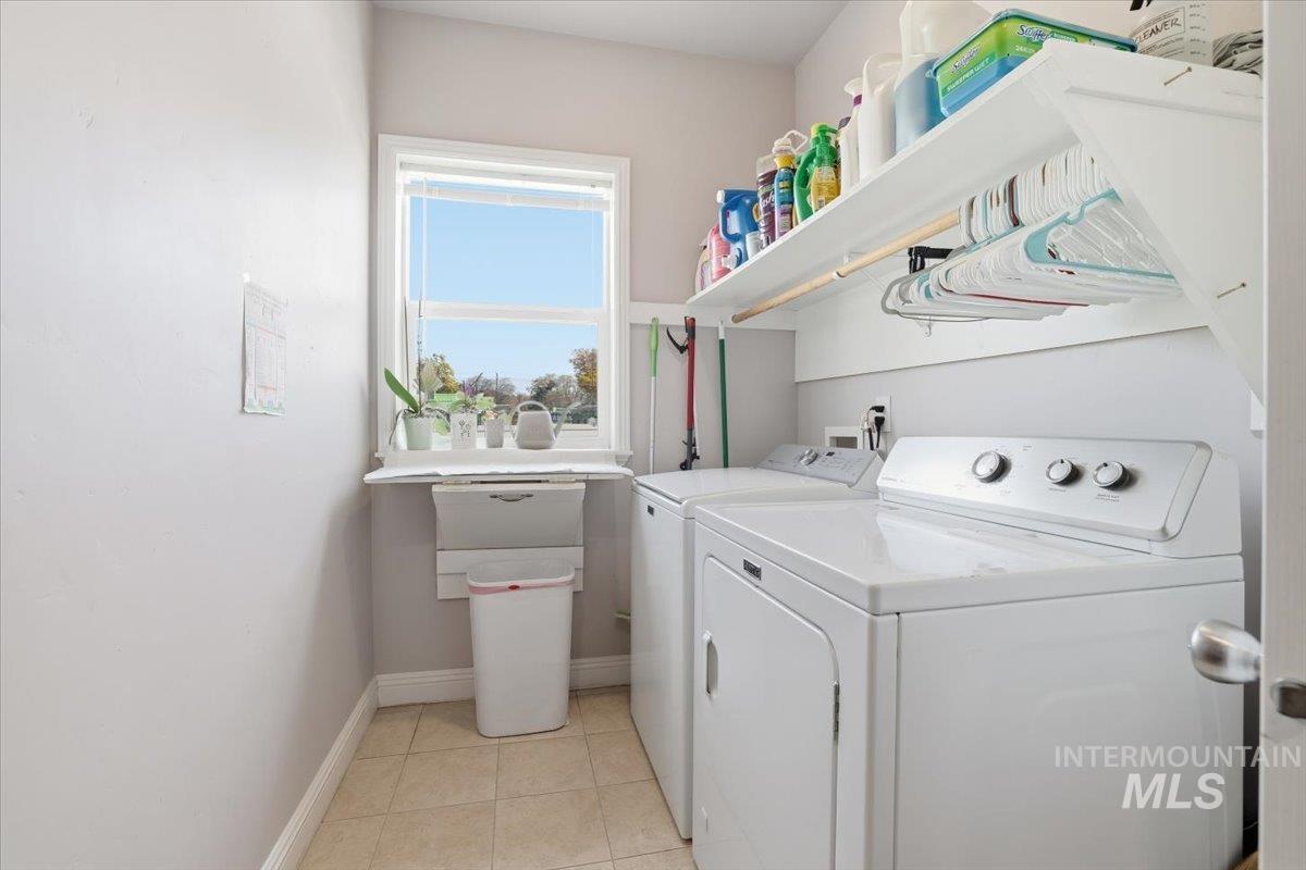 Washroom featuring washing machine and dryer and light tile patterned floors