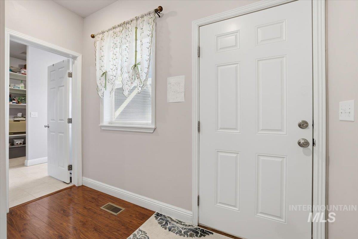 Foyer featuring light wood-style flooring and baseboards