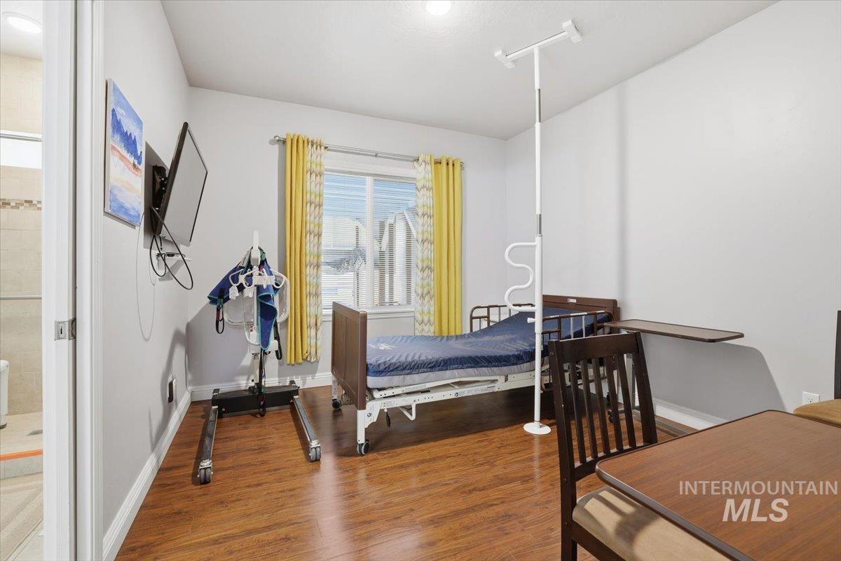 Bedroom featuring wood finished floors and baseboards