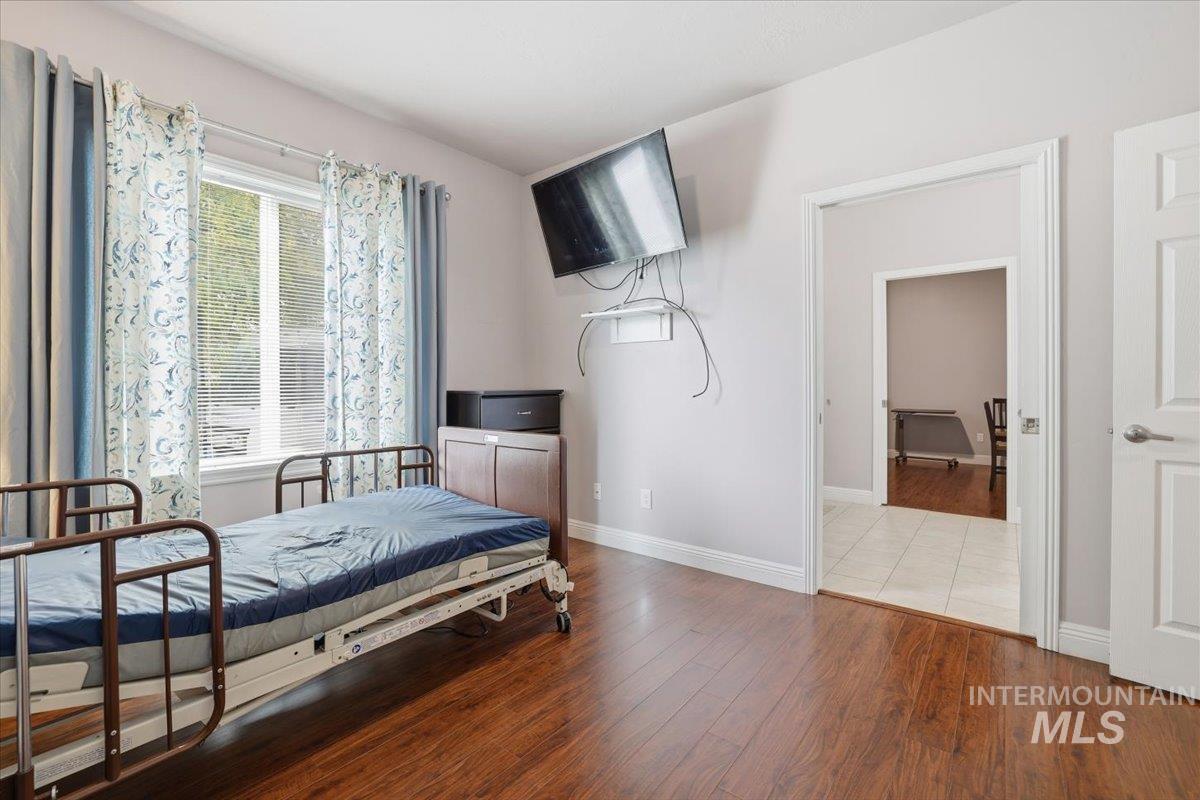 Bedroom featuring wood finished floors and baseboards