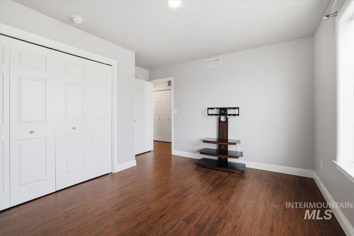 Unfurnished bedroom featuring dark wood finished floors and a closet