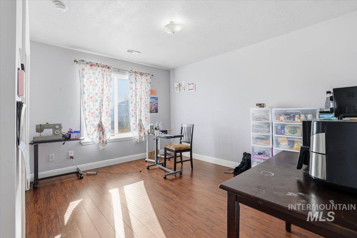 Office featuring dark wood finished floors and a textured ceiling