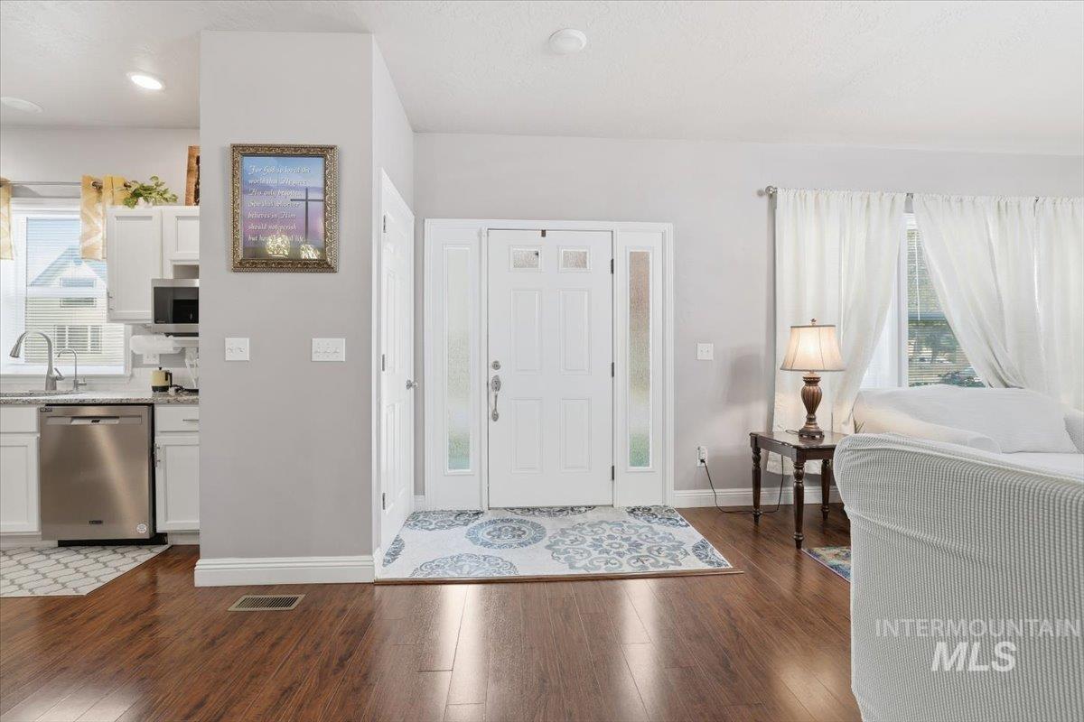 Foyer entrance featuring healthy amount of natural light and dark wood finished floors