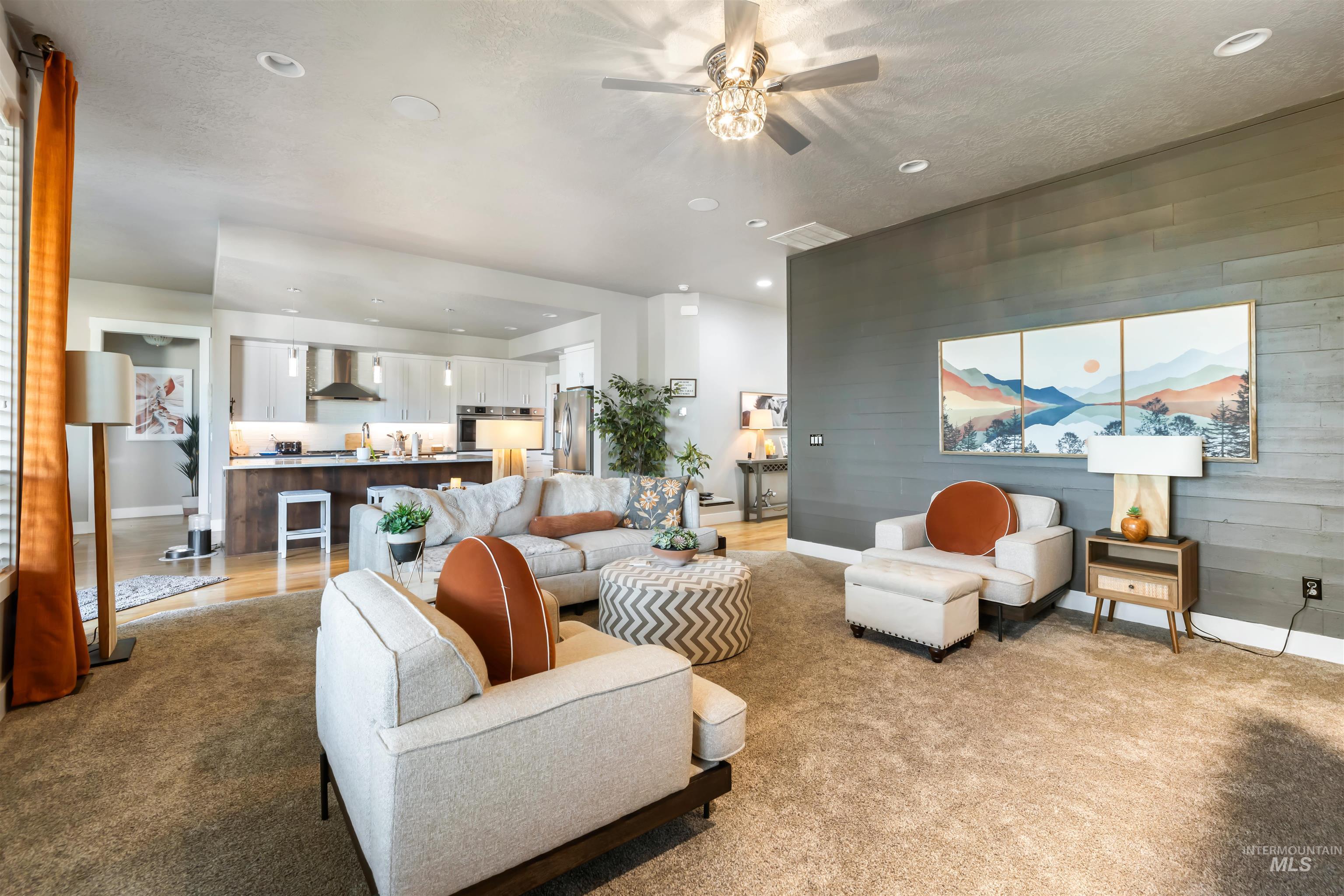 Living room with recessed lighting, wooden walls, and light colored carpet