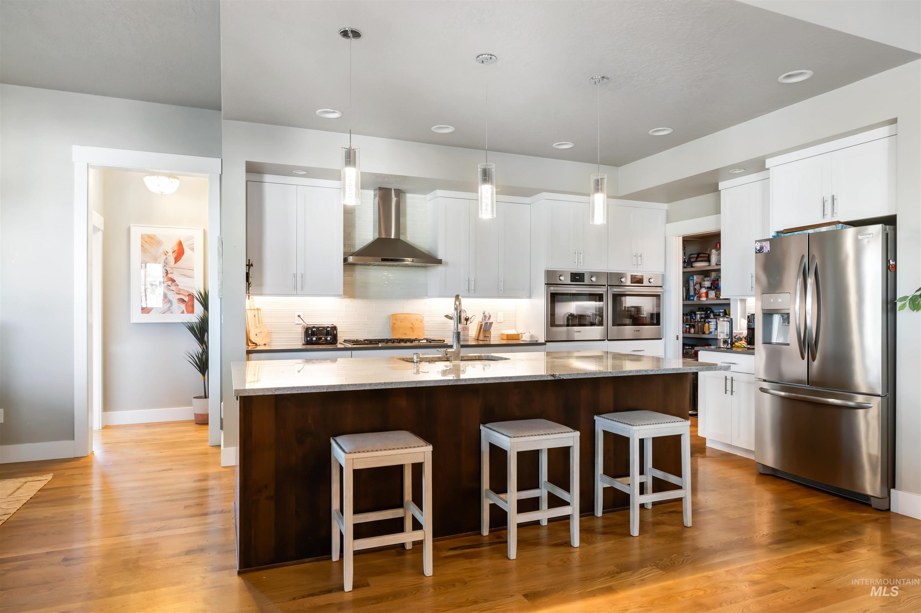 Kitchen featuring appliances with stainless steel finishes, pendant lighting, white cabinets, and recessed lighting