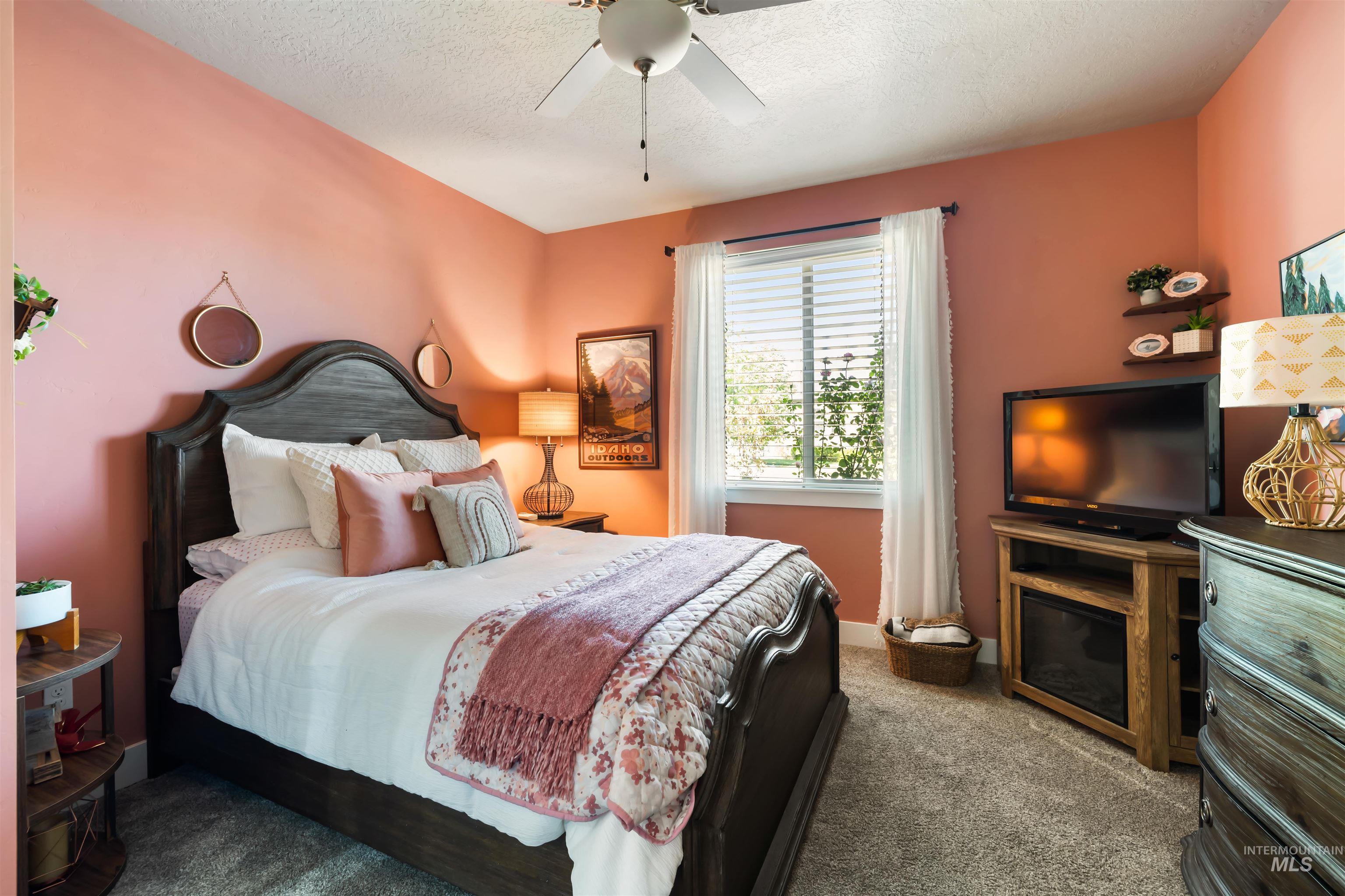 Bedroom featuring carpet flooring, a ceiling fan, and a textured ceiling