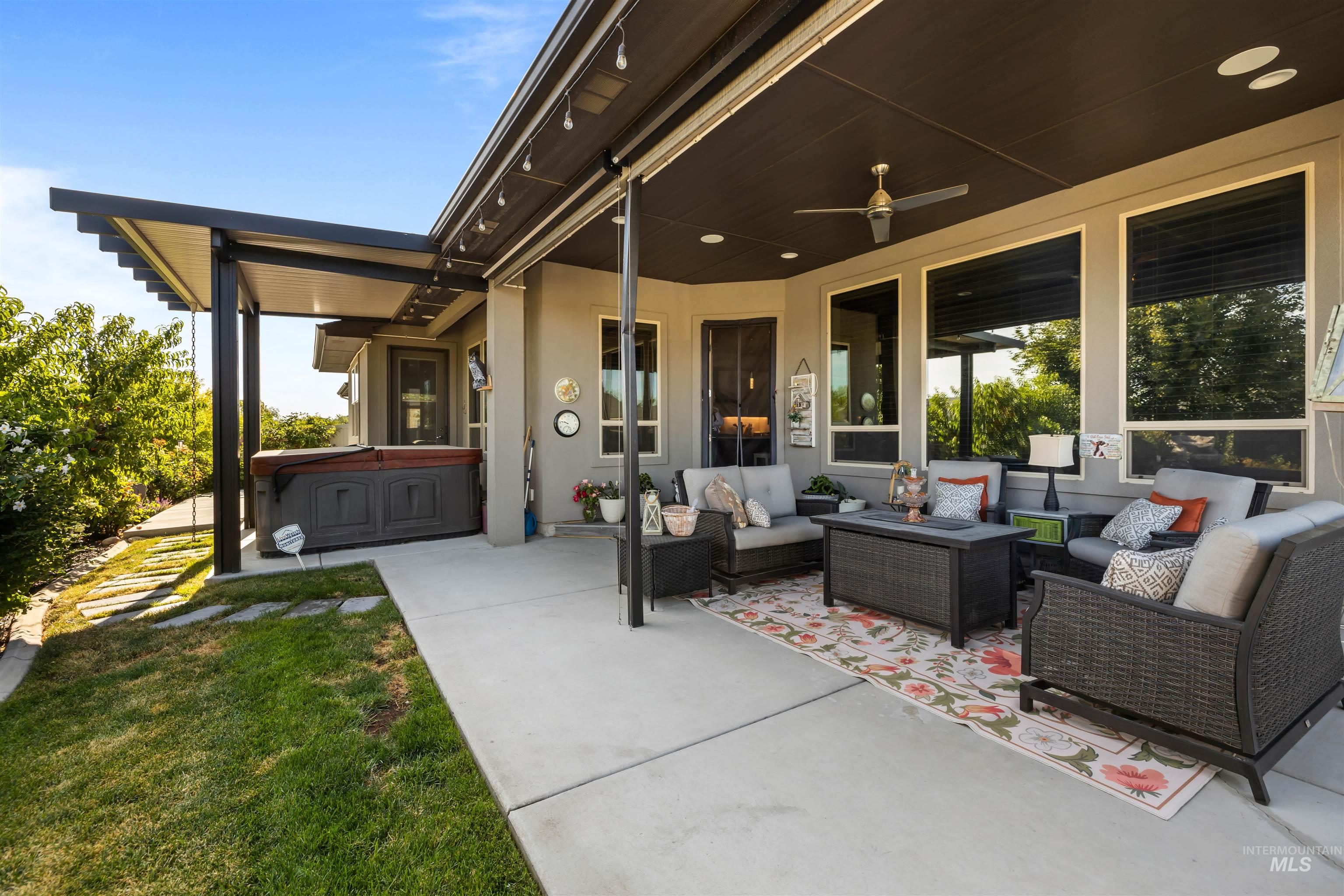 View of patio / terrace with a hot tub, an outdoor hangout area, and ceiling fan