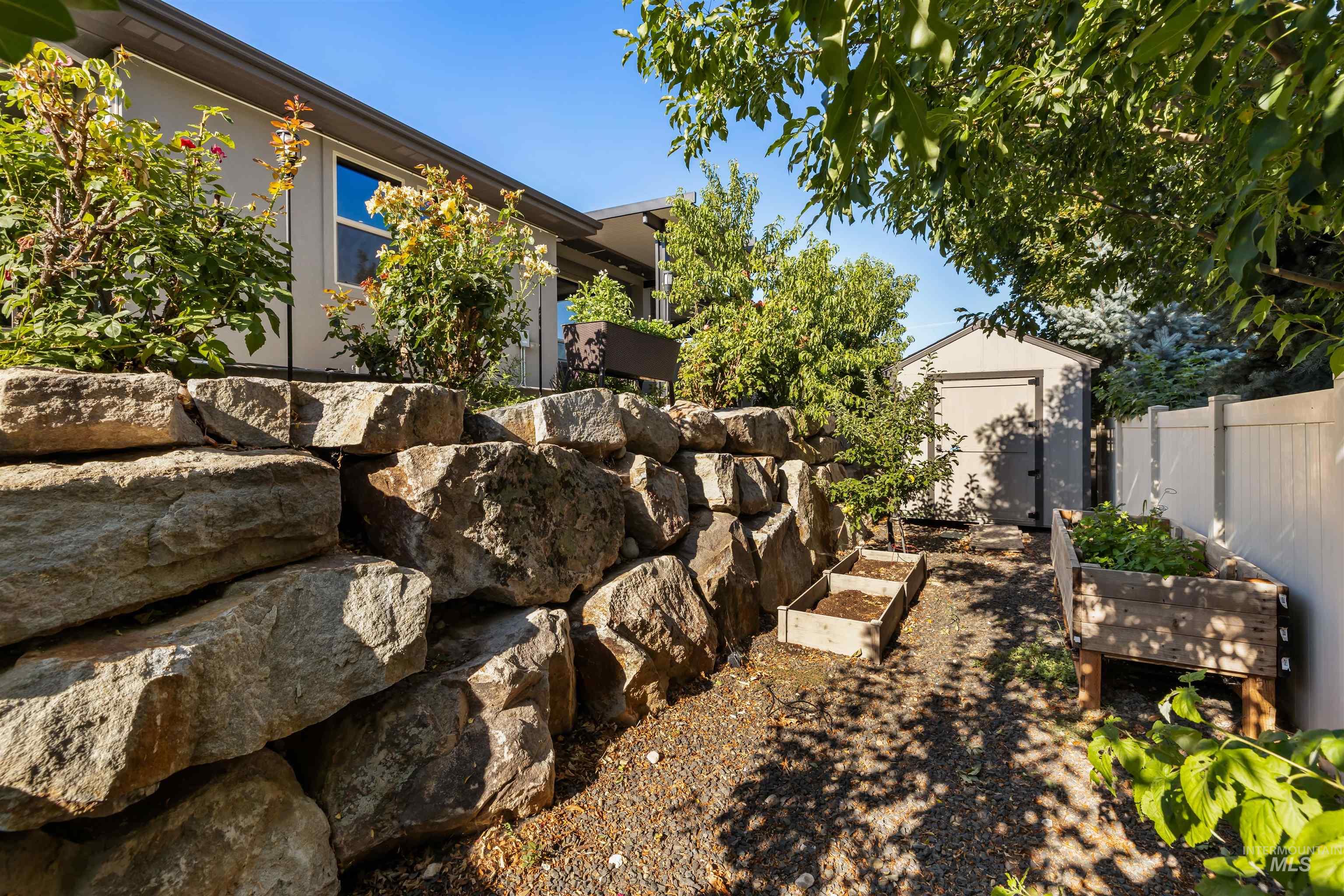 View of yard featuring a vegetable garden and a storage unit