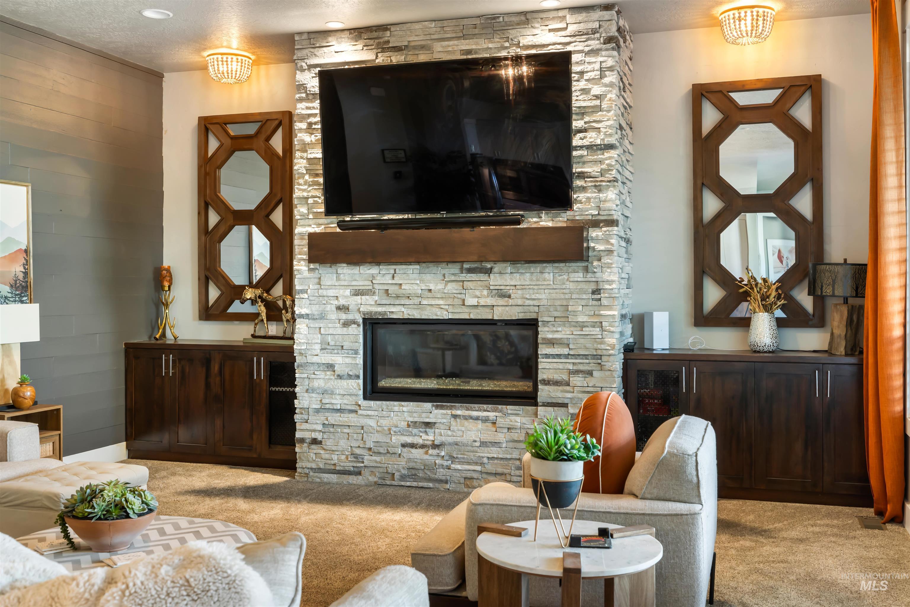 Carpeted living area featuring a stone fireplace and a textured ceiling