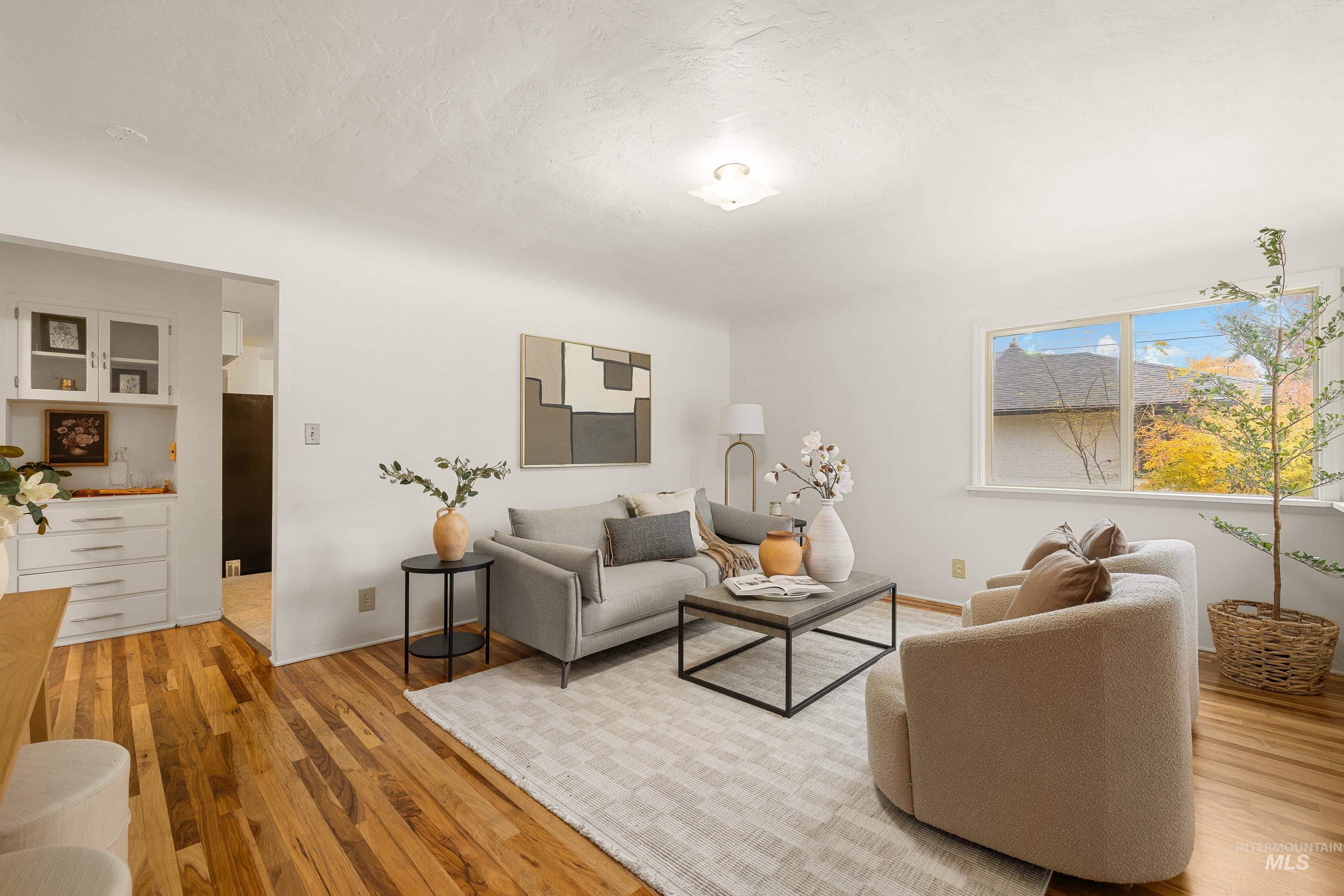 Living area featuring light wood-type flooring and a textured ceiling