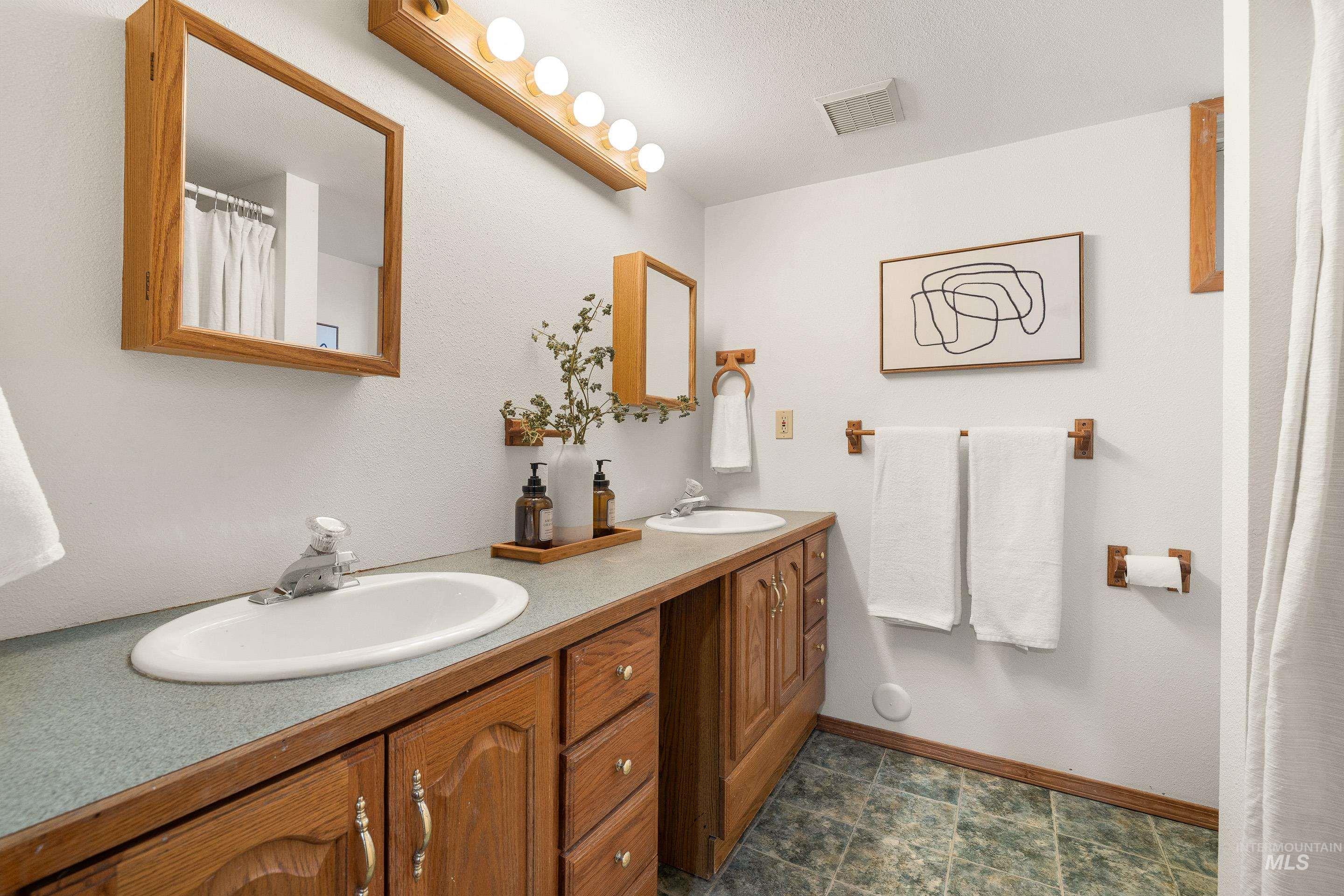 Bathroom with a shower with curtain and double vanity