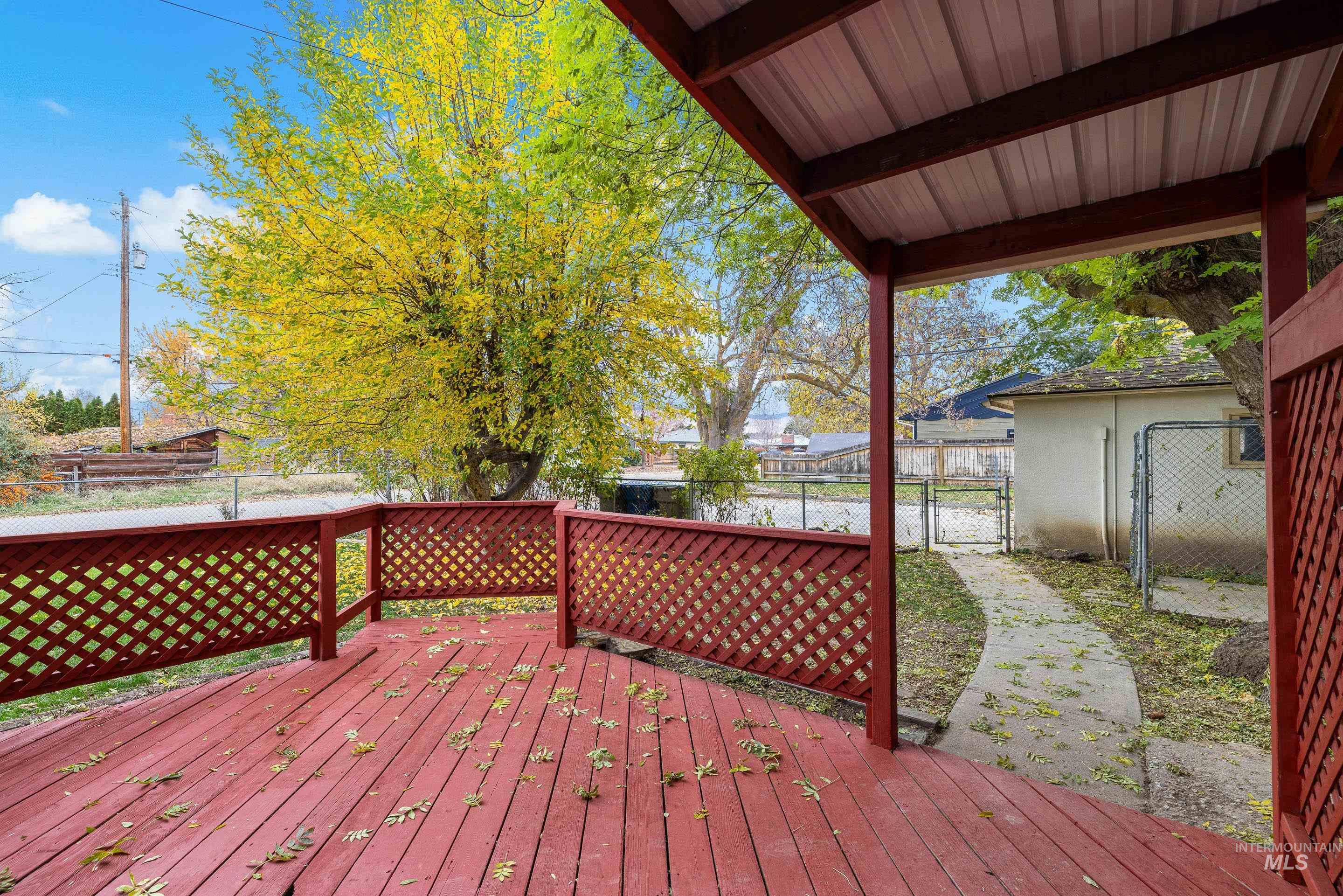 Wooden terrace featuring a fenced backyard and a gate