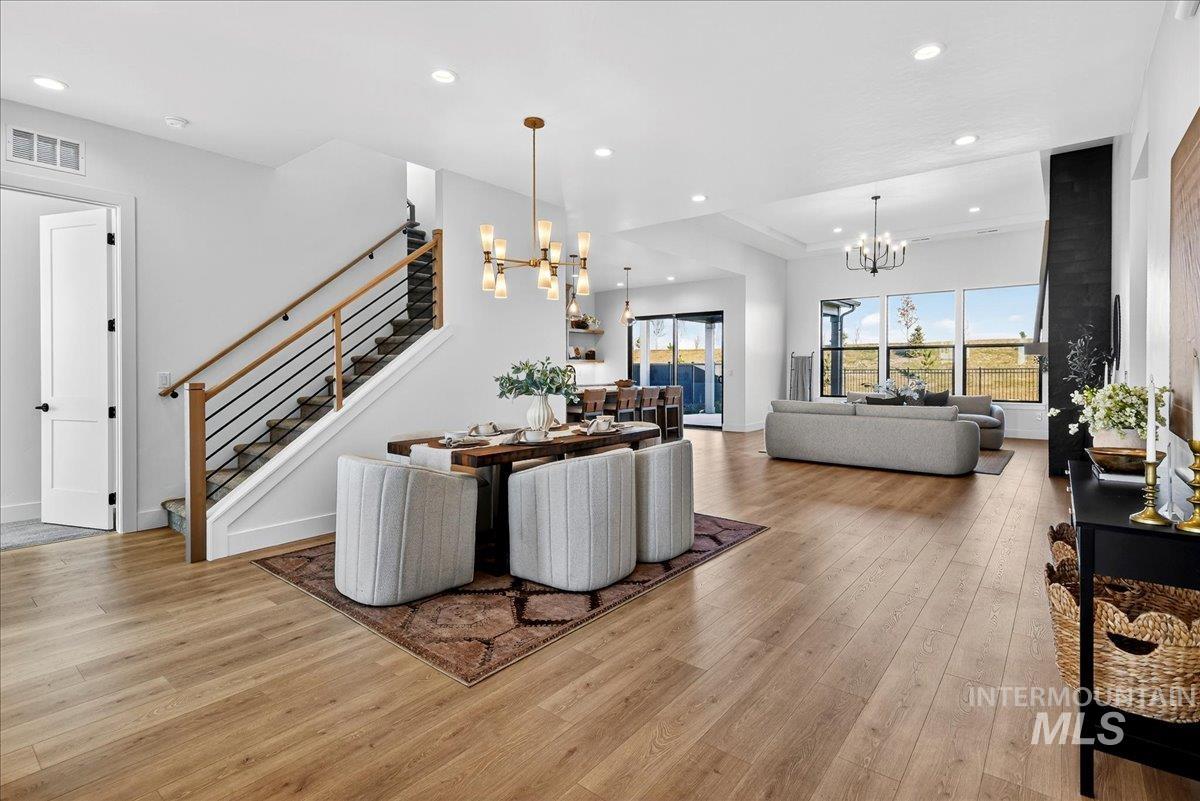 Dining area featuring recessed lighting, light wood finished floors, a chandelier, and stairs