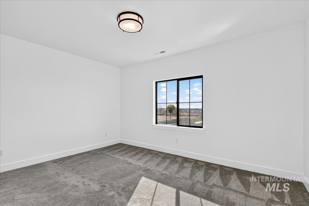Carpeted empty room featuring baseboards