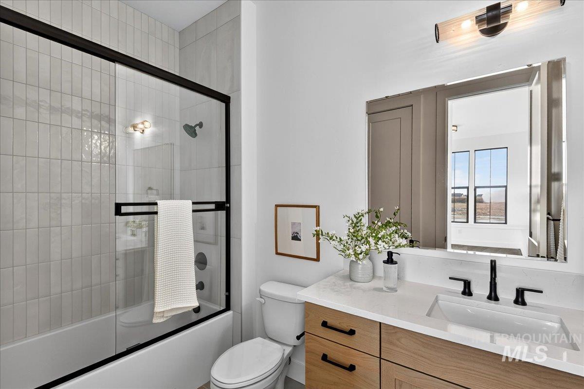 Bathroom with shower / bath combination with glass door and vanity