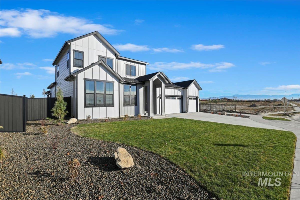 Modern inspired farmhouse featuring board and batten siding, concrete driveway, and a mountain view