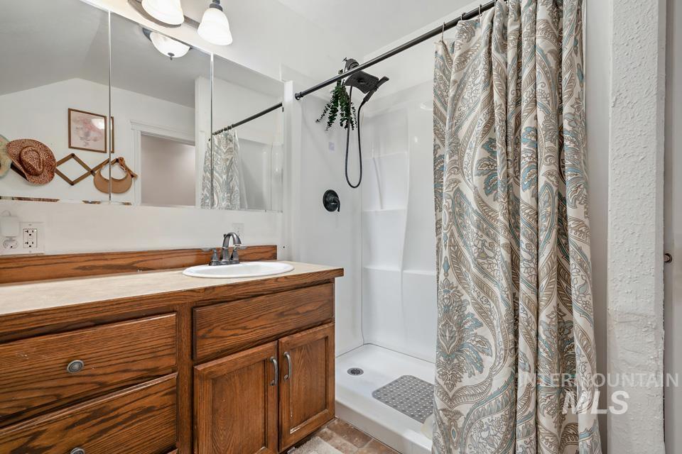 Full bathroom featuring a shower stall and vanity
