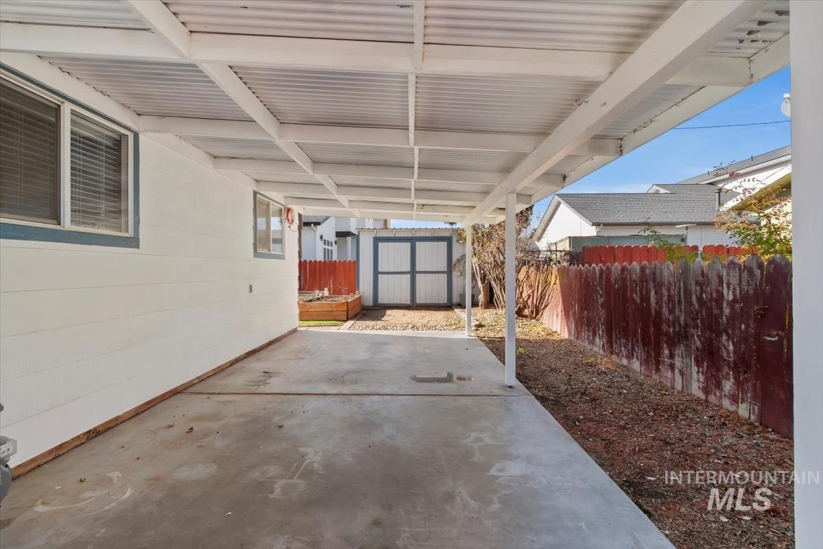 Fenced backyard with a shed and a patio