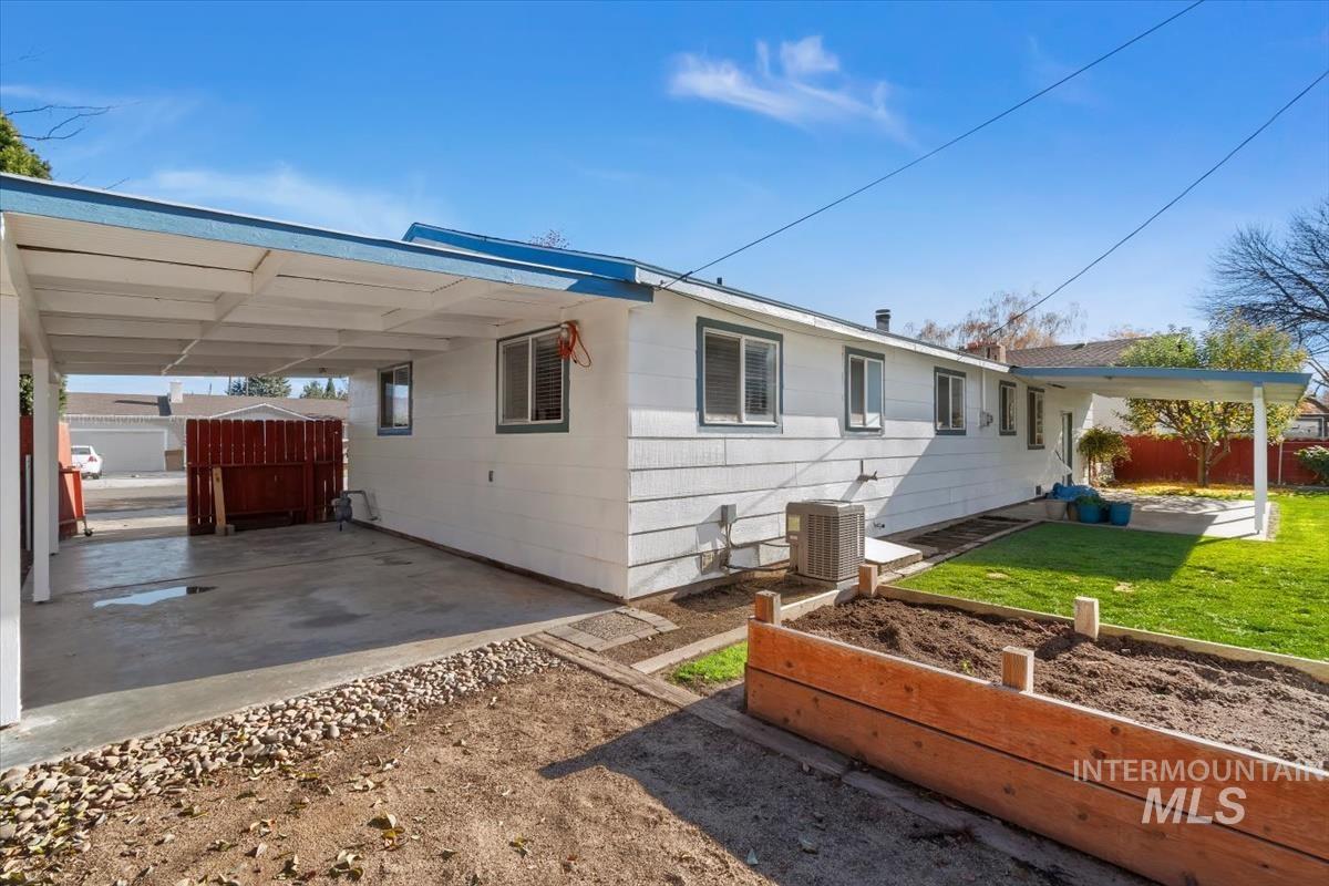 View of home's exterior with a vegetable garden, a patio, and a carport