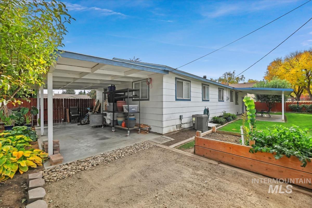 View of front of property featuring a vegetable garden and a patio area