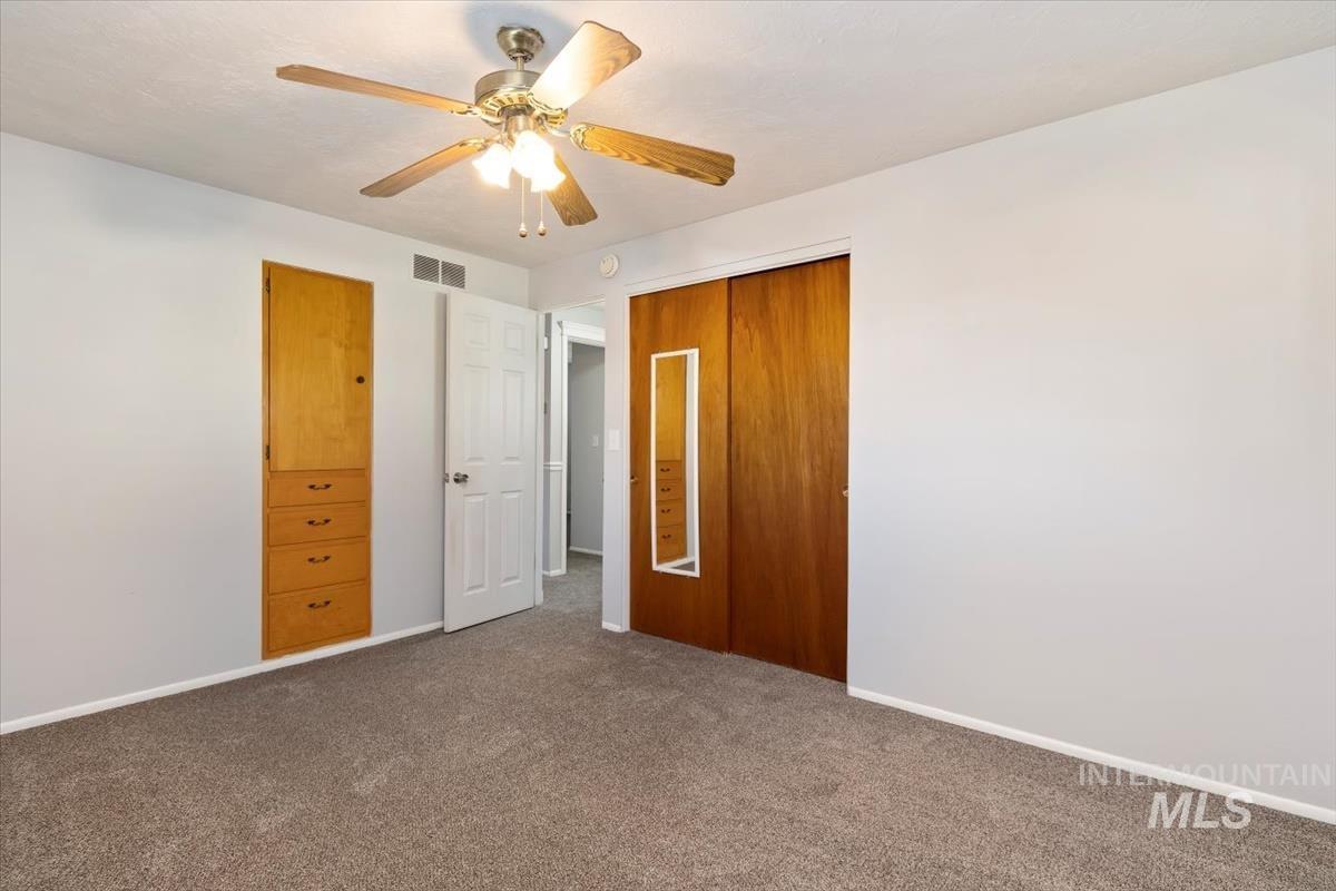 Unfurnished bedroom featuring carpet floors, a ceiling fan, and a closet
