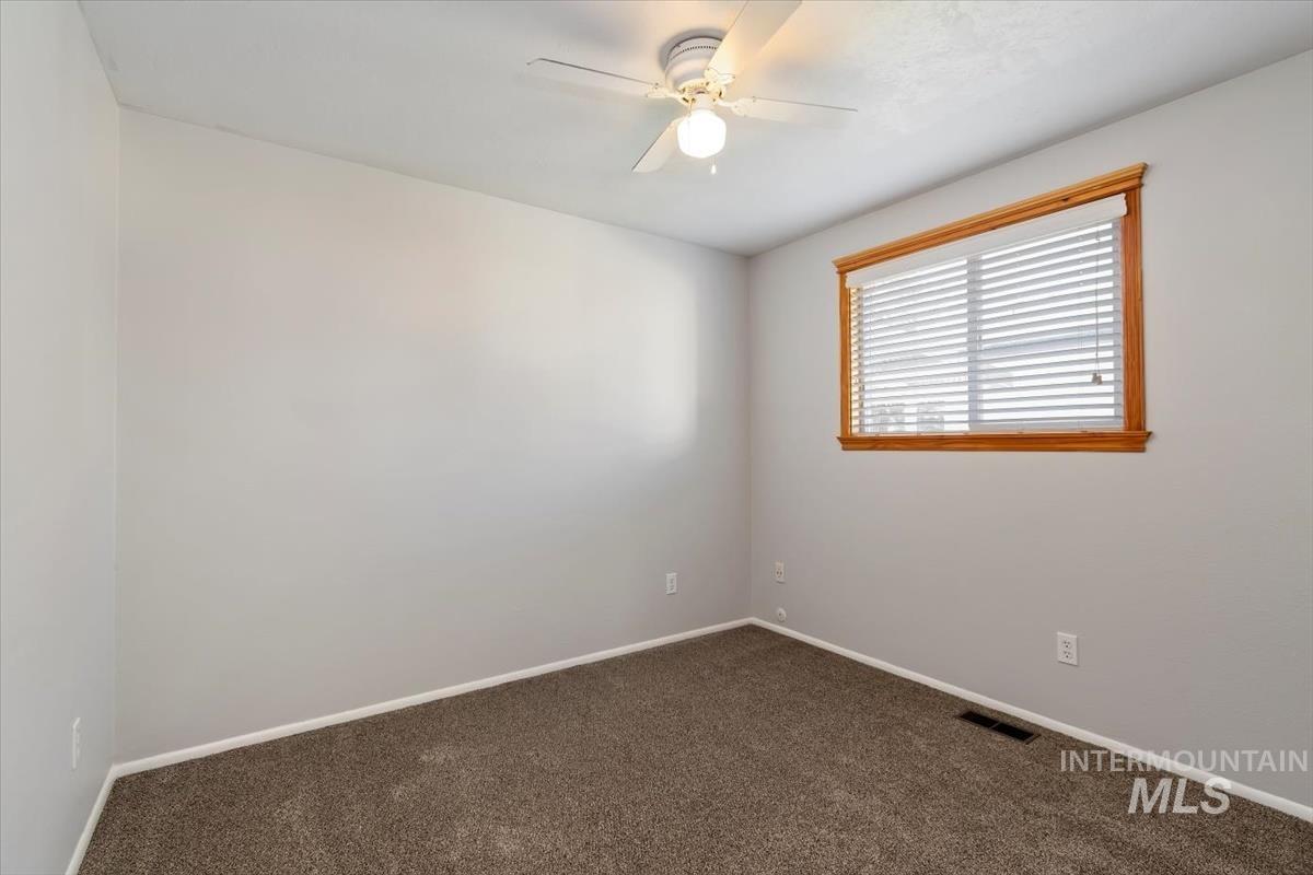 Unfurnished room featuring carpet flooring and ceiling fan