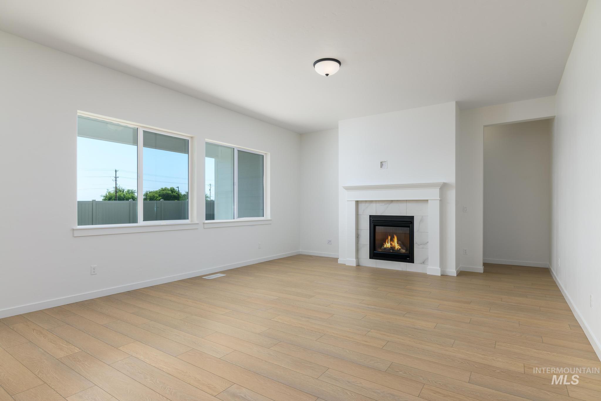 Unfurnished living room featuring a fireplace and light wood finished floors
