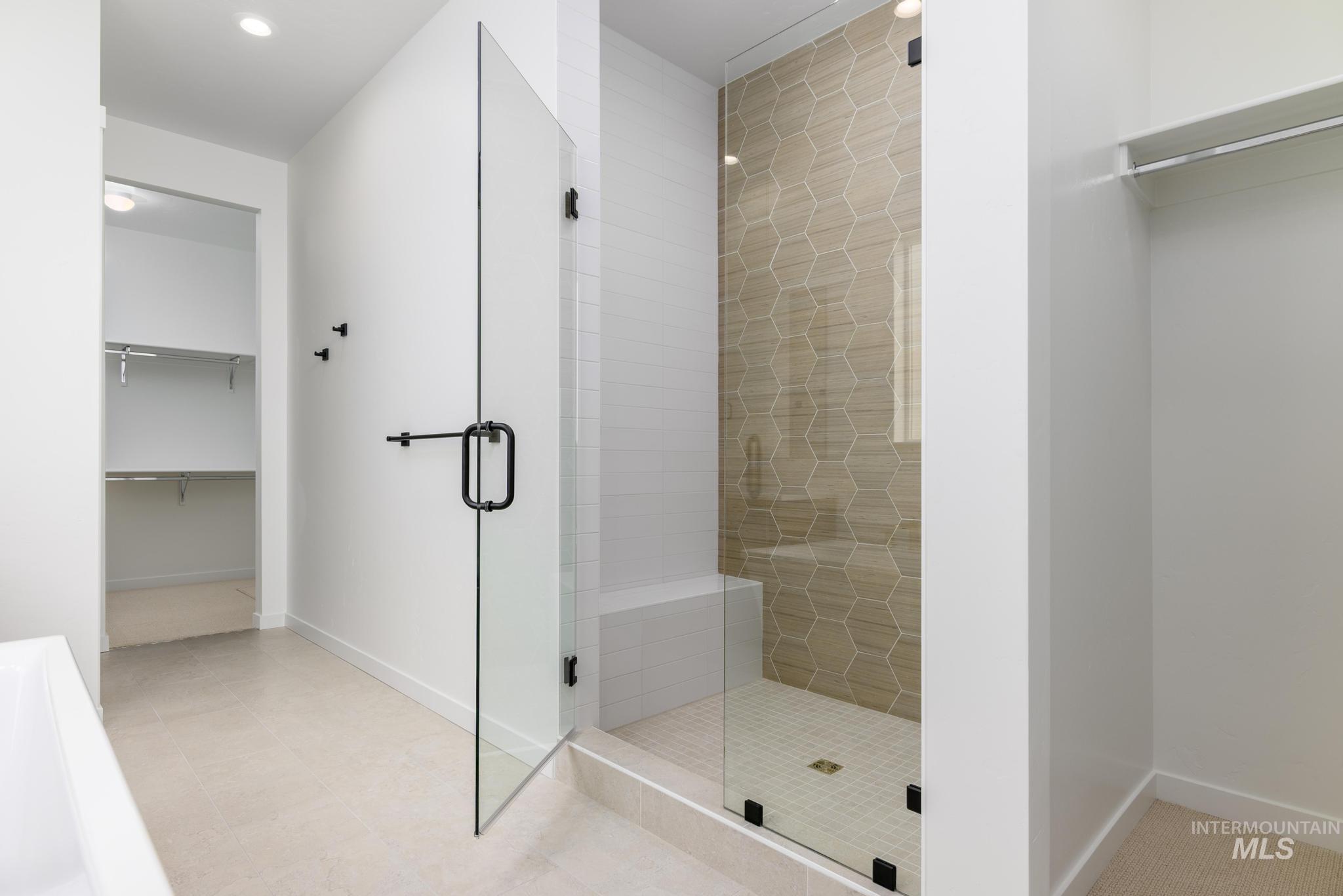 Bathroom featuring a stall shower, a walk in closet, and recessed lighting