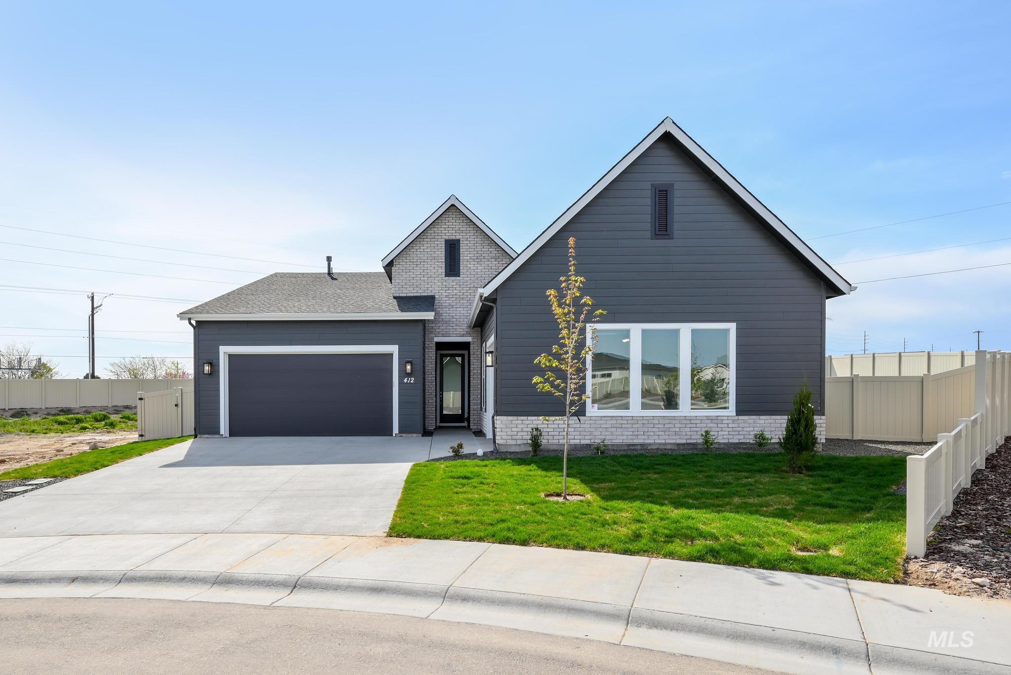 View of front of home with a garage, driveway, and roof with shingles
