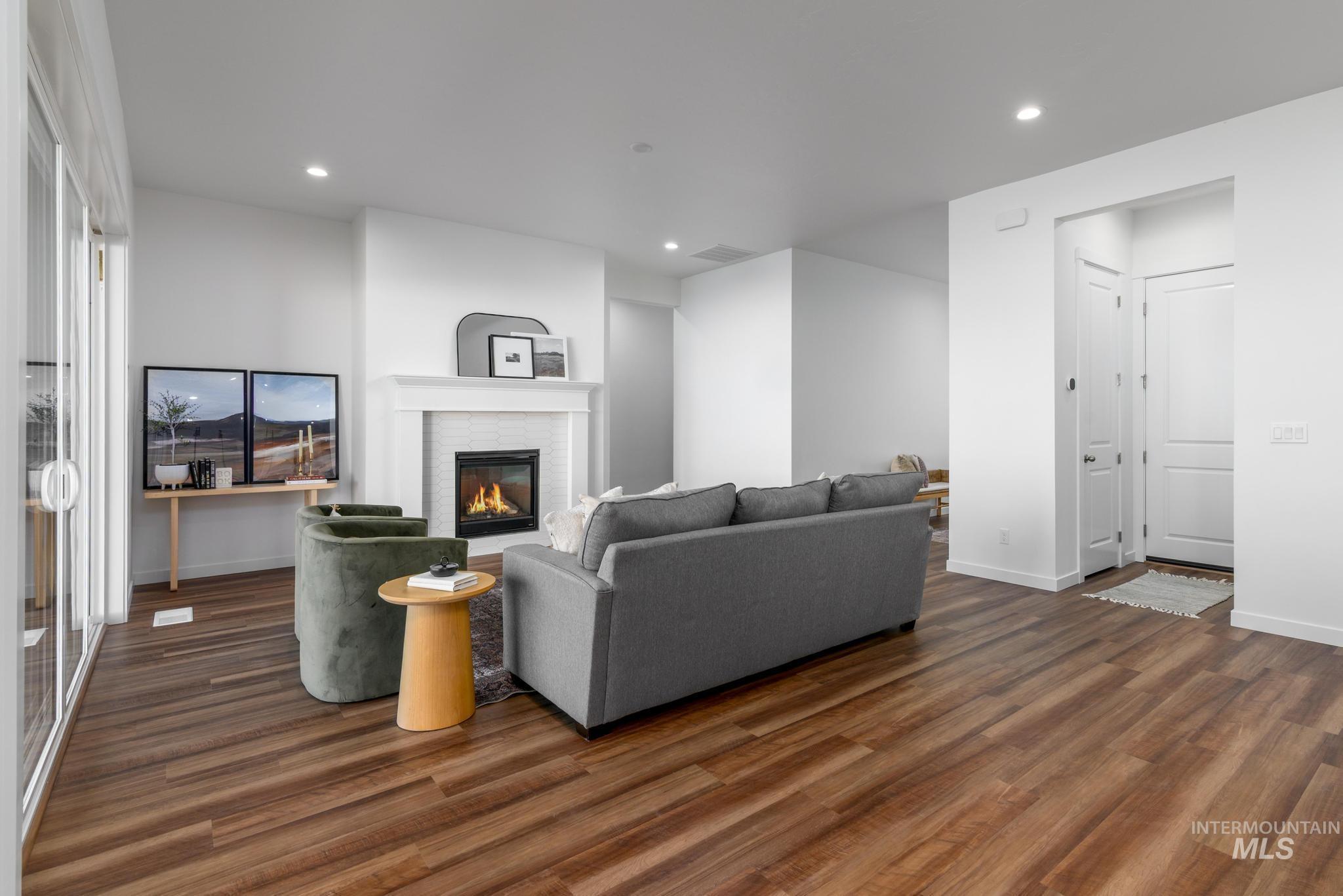 Living room featuring wood finished floors, a fireplace, and recessed lighting